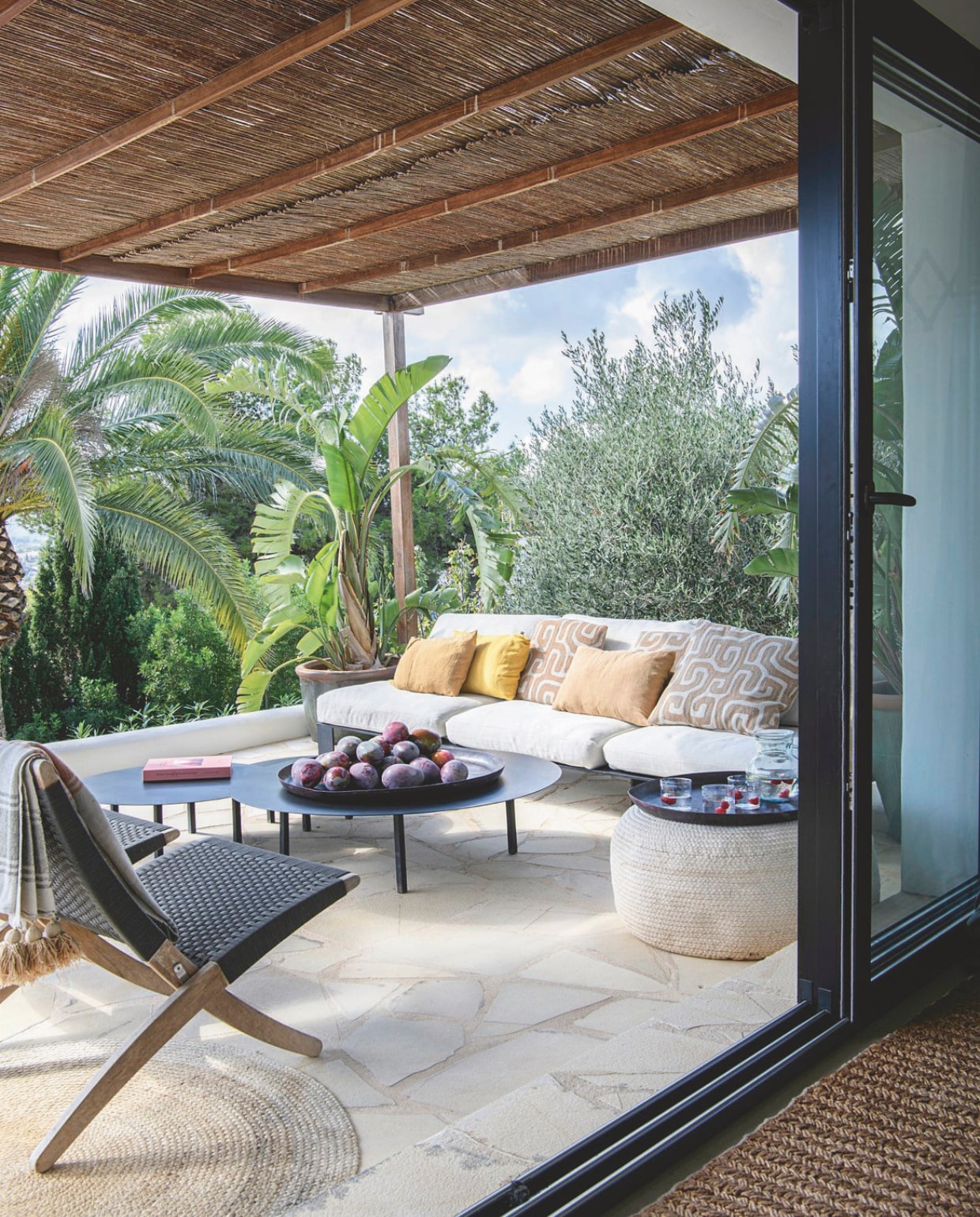 Buitenstoelen Carl Hansen, bijzettafels, buitenbank Serax. Schalen en plaid House Doctor.Vloerkleed Ferm Living, kussens Haomy. vtwonen 8-2025 | styling Inge van Lieshout | fotografie Louis Lemaire