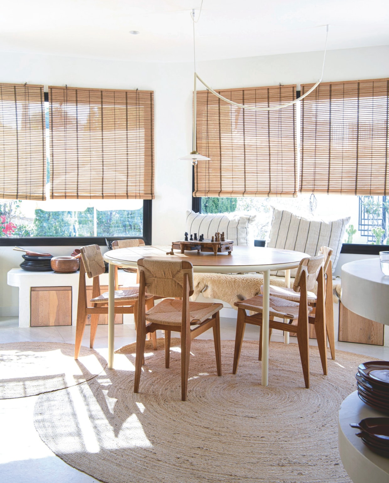 Vloerkleden, witte kussens met strepen Ferm Living, eettafel Valerie Objects, eetkamerstoelen Gubi, bank zelfgemaakt. Raambekleding en pan lokale markt. Borden Indigena. vtwonen 8-2025 | styling Inge van Lieshout | fotografie Louis Lemaire
