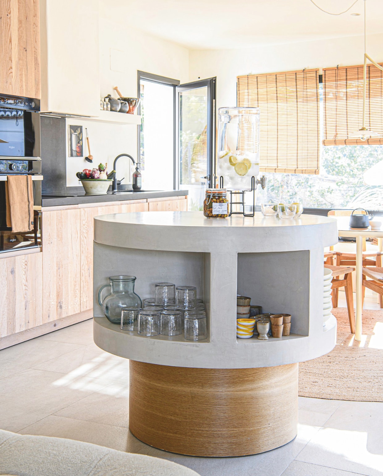 Ronde keukeneiland van hout en mortex ontworpen door Ilse. Keuken lokale keukenbouwer. Theedoek Haomy, kruidenpotjes Dille & Kamille. vtwonen 8-2025 | styling Inge van Lieshout | fotografie Louis Lemaire