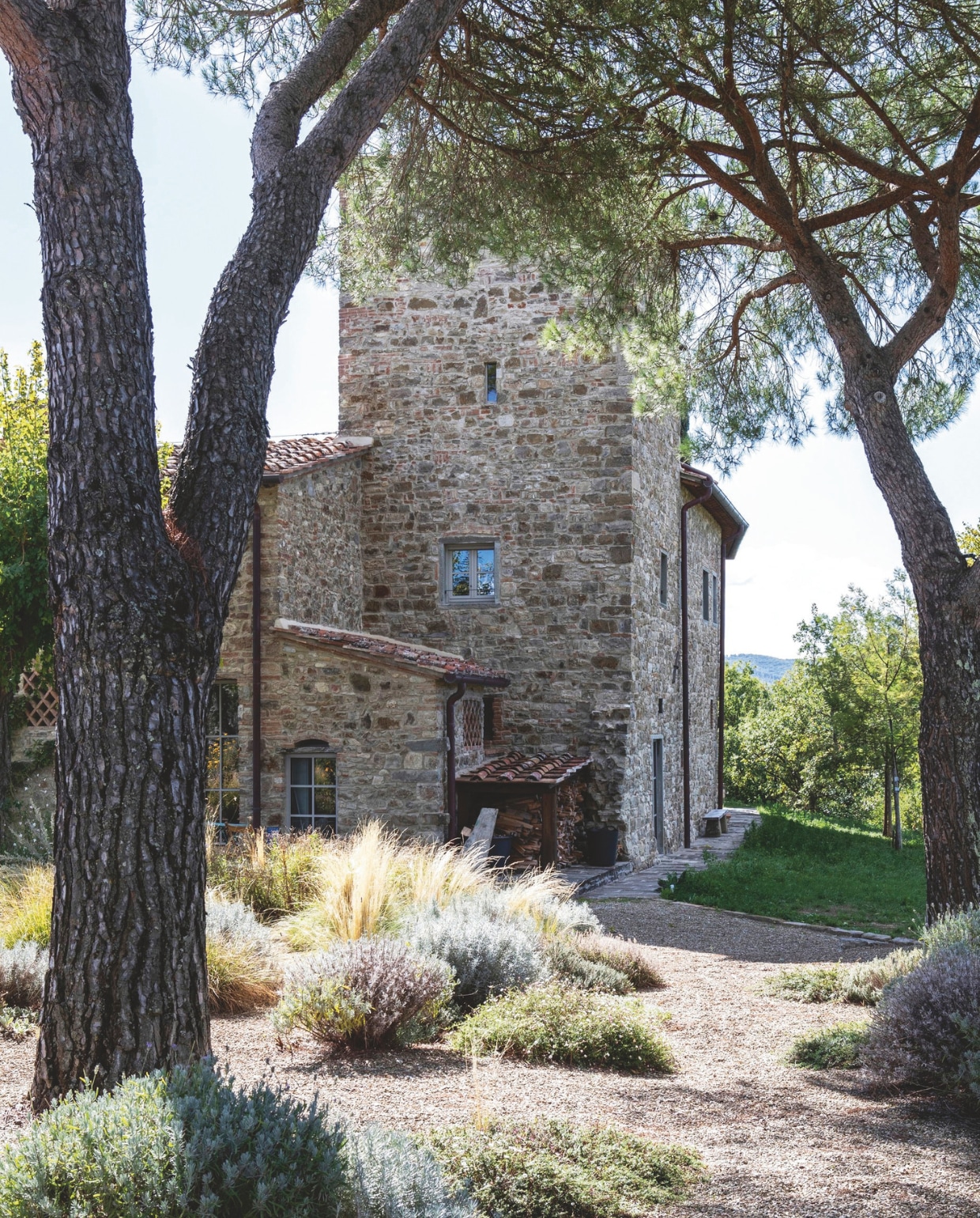 Zicht op destenen boerderij gebouwd rond de 14e-eeuwse toren.  vtwonen landelijk 7-2025 | productie Living Inside | fotografie Monica Spezia