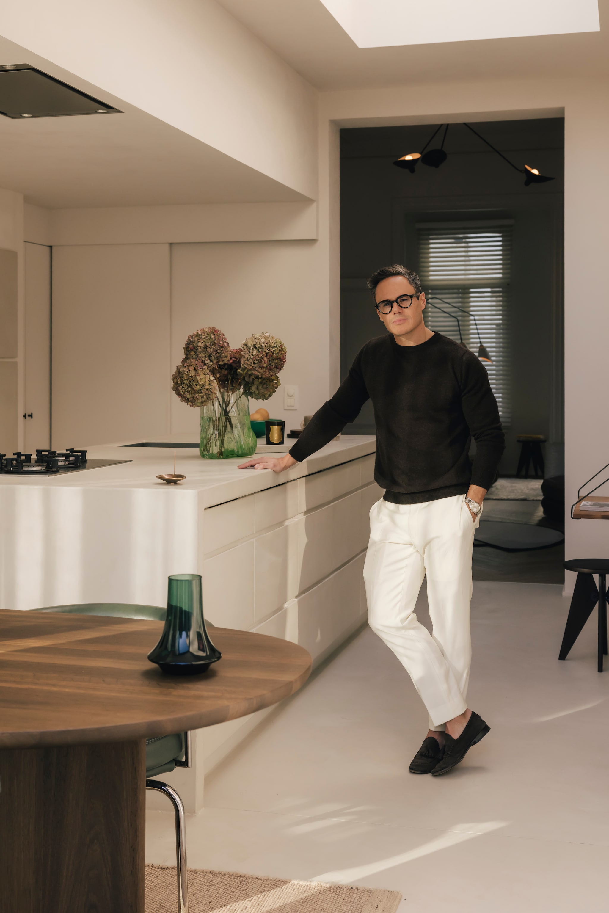 De lichte keuken werd bewerkt met betonstuc van Aqua Sensa van Boss Paints. Vooraan tafel Dew van Sabine Marcelis voor Arco, die Nachtergaele bij de ontwerpster zelf aankocht. Op tafel handgeblazen vaas Spinn van XLBoom, een cadeau van de bevriende ontwerper Frederik Delbart. Het limited edition vloerkleed is van het Milanese Studiopepe x JOV. Stijlvol wonen 9-2025 | Katoo Peeters