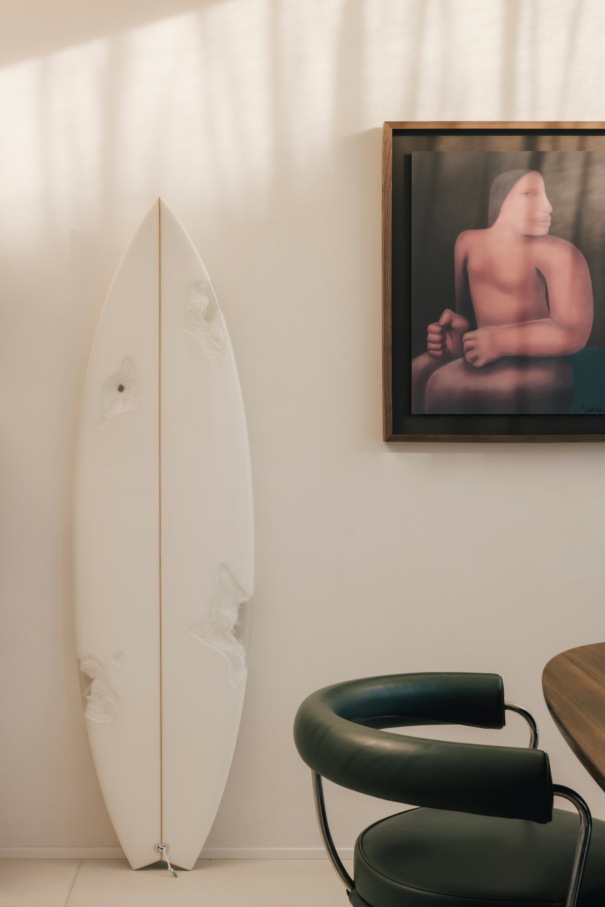 Voor zijn veertigste verjaardag kocht Nachtergaele een limited edition kunstobject: eroded surfboard Hayden X Daniel Arsham. Daniel Arsham is een toonaangevende kunstenaar uit New York waar Nachtergaele veel bewondering voor heeft. Ernaast eetkamerstoel LC7, van Charlotte Perriand, in productie bij Cassina en de ingelijste lithografie van George Rouy. Stijlvol wonen 9-2025 | Katoo Peeters