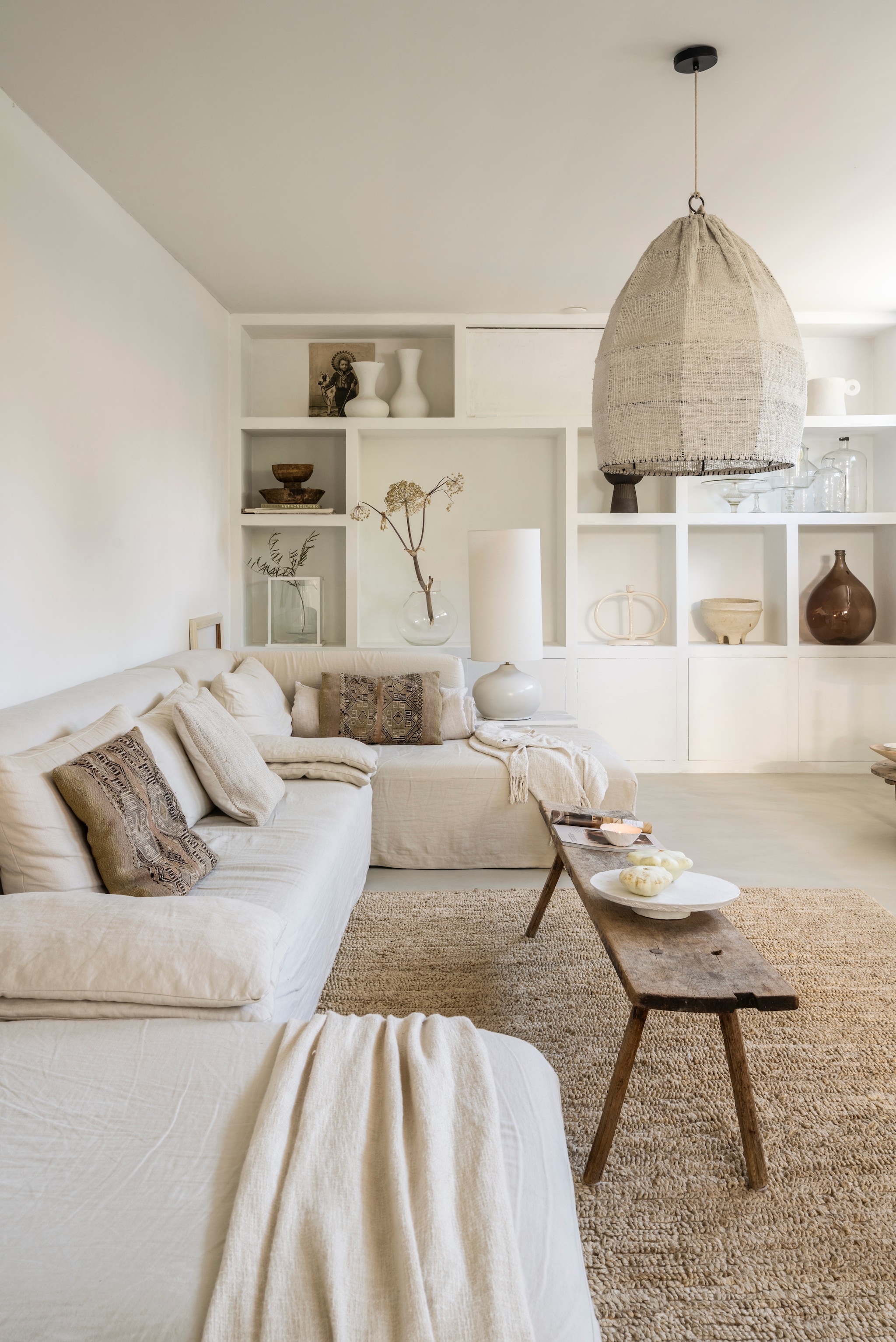 Linnen bank L’Authentique. Gekleurde kussens uit Marrakech. Witte pompoenen en kom Atelier November.  Vintage slagerstafel.  Hanglamp Mo’s Interior Art. Taartschaal @voc2012. Kast op maat gemaakt, geschilderd met stuccoverf van L’Authentique. Tafellamp Kwantum. Vloerkleed Pomax. vtwonen Landelijk 10-2025 | styling Marianne Luning | fotografie Stan Koolen