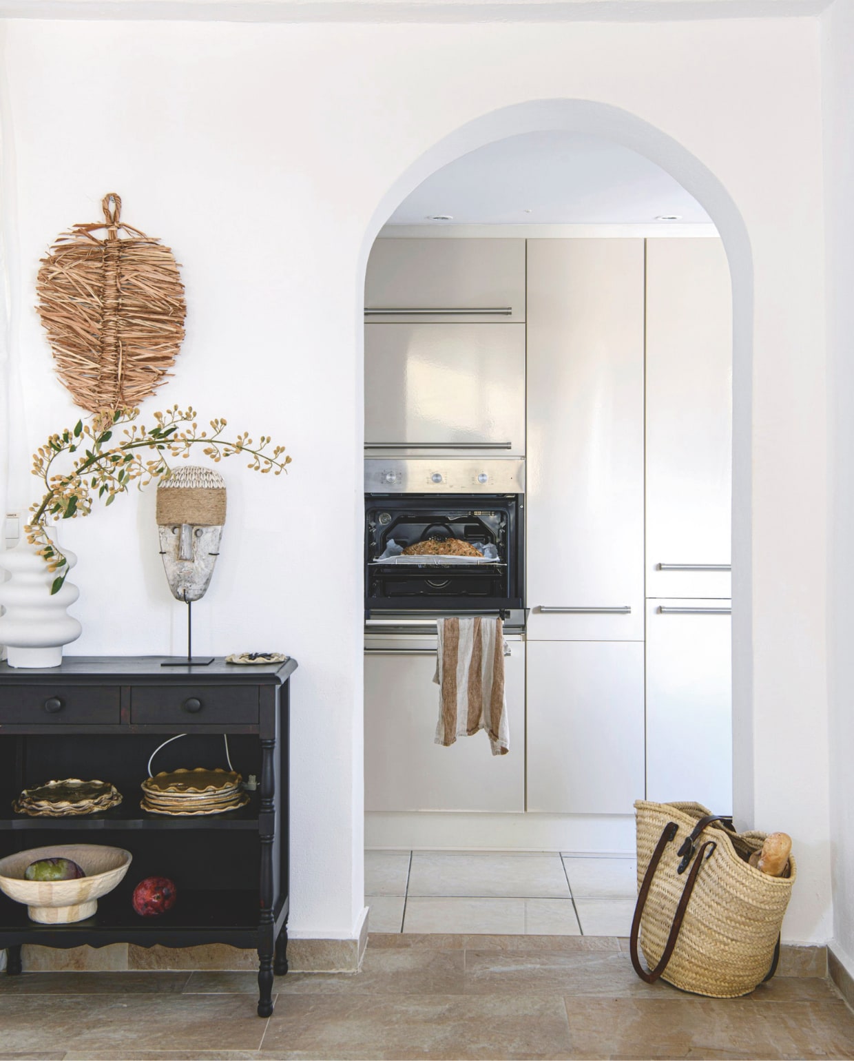 Keuken en kastje vorige bewoners, vaas Jysk, masker A-style Altea. Keramiek Caroline Wolberts, schaal No 45 at Sea. Tas Gata de Gorgos, theedoek Gretas Design. vtwonen 8-2025 | productie Inside Homepage | styling Inge van Lieshout | fotografie Louis Lemaire