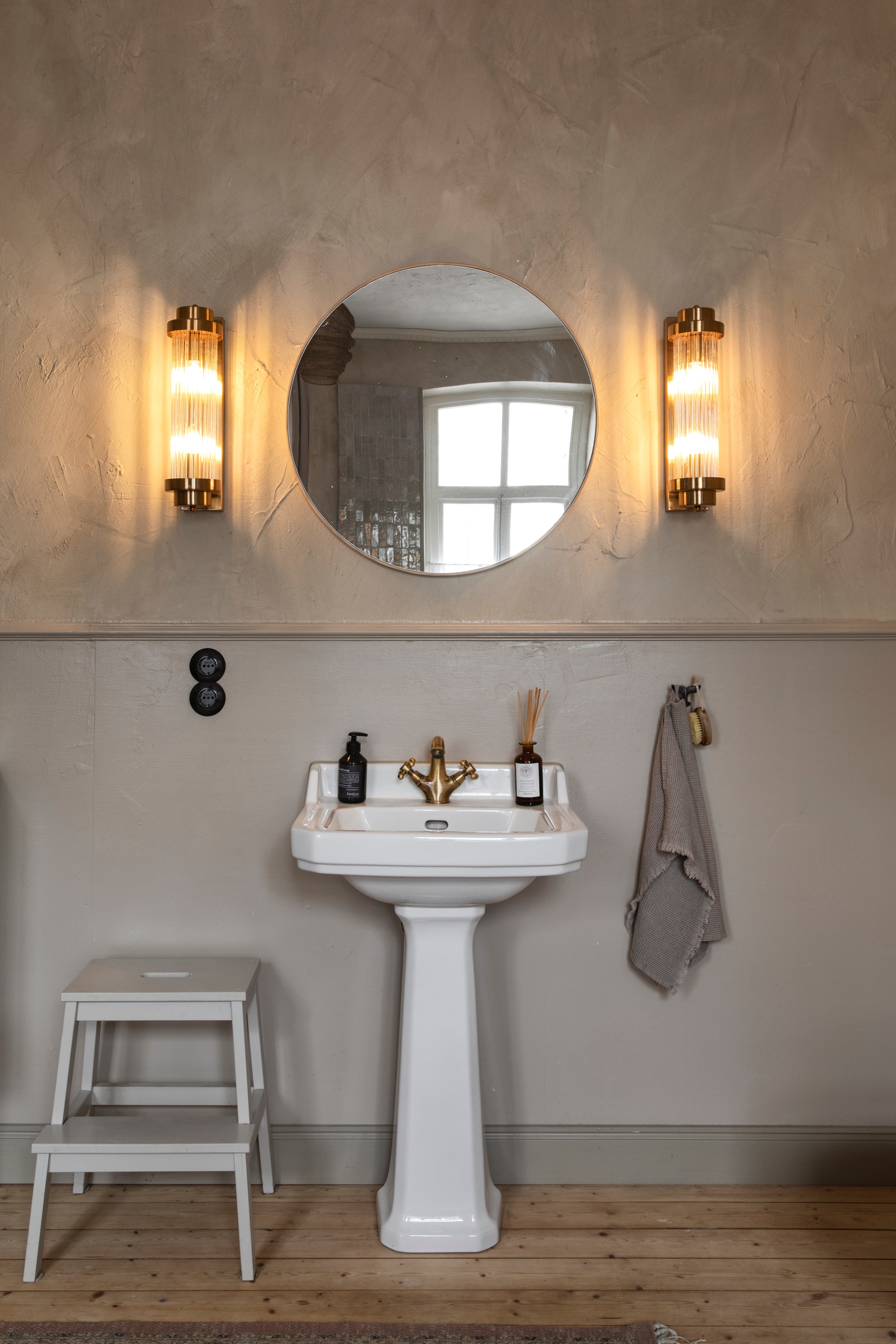 Wastafel Richmond en kraan Elizabeth in satijn goud van Hudson Reed. Art-decowandlampen Viénta van Suitta. vtwonen Landelijk 11-2025 | styling Miriam Hannemann | fotografie André Reuter