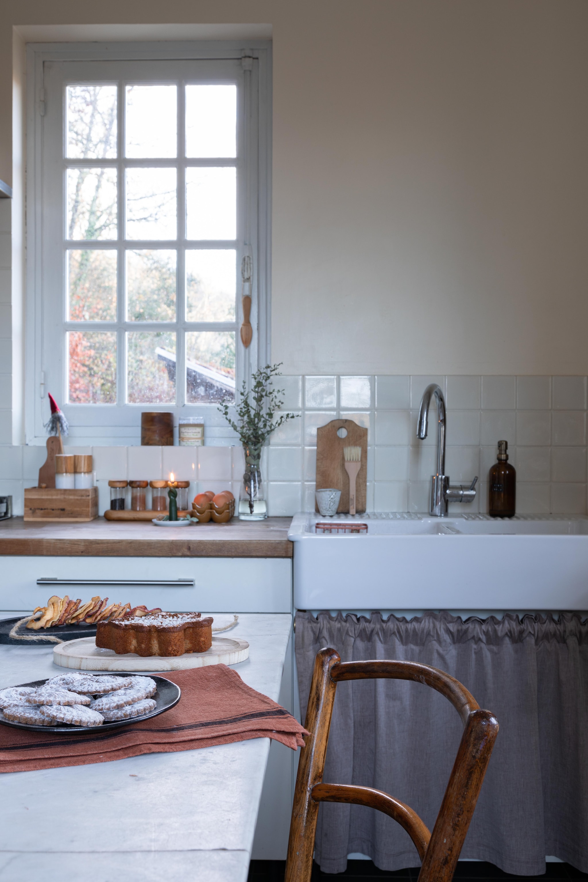 De moderne Ikea-keuken zat al in het huis, maar kreeg een opfrisbeurt door de rvs gootsteen te vervangen door een porseleinen exemplaar - soortgelijk The Classic House - en een gordijntje eronder te hangen. vtwonen Landelijk 11-2025 | styling Wilma Custers | fotografie Fabienne Delafraye