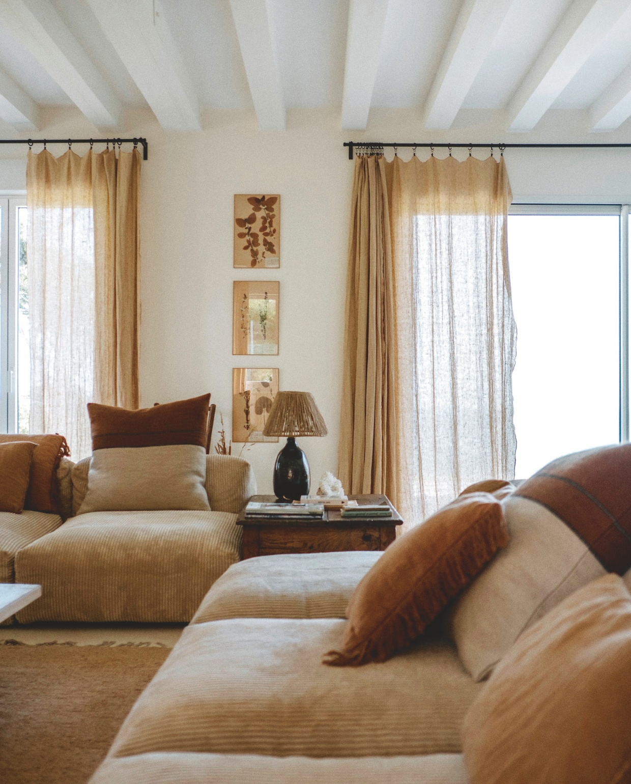 Elementenbank Vetsak. Kussens naar ontwerp van Florence Poncet. Kleed Nunamae. Fotolijsten Maison de Vacances. Bijzettafel en lamp lokale antiekwinkel. vtwonen landelijk | styling Florence Poncet | fotografie Julien Hay