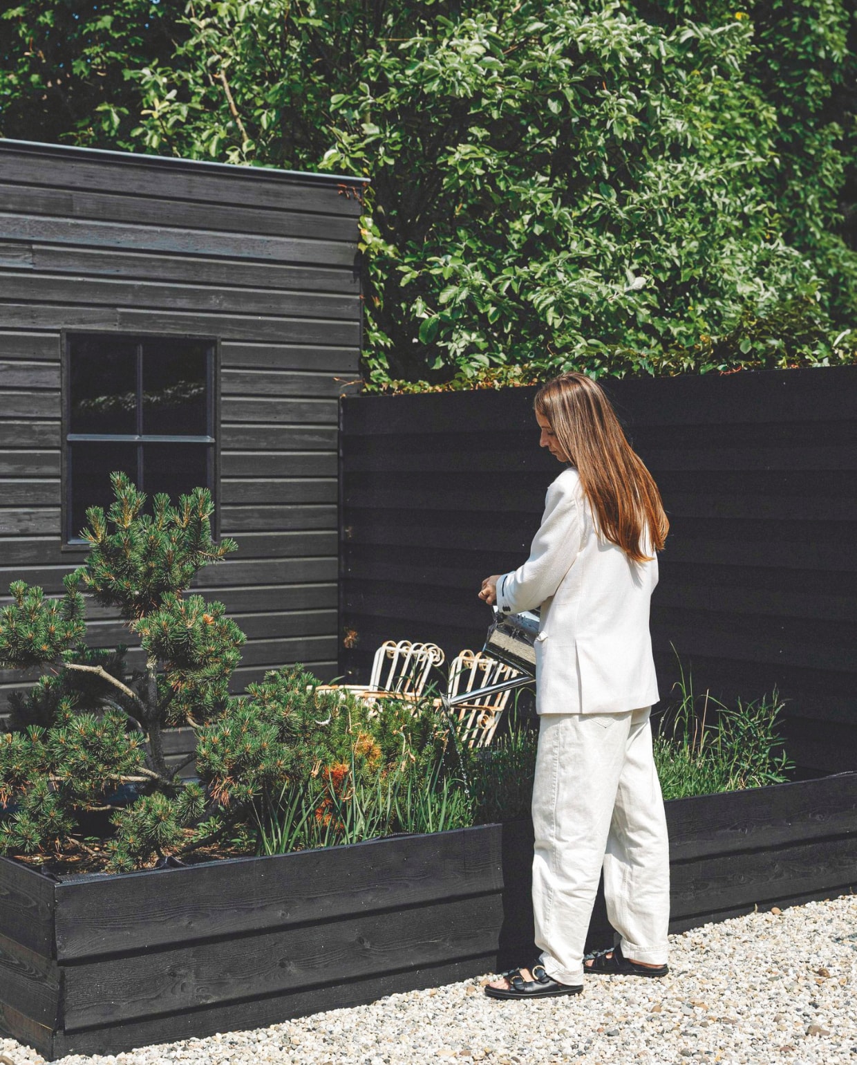 Tuinhuis antracietgrijs geschilderd met verf van Sikkens. Plantenbak zelfgemaakt. Stalen antieke stoelen Leeelijk. vtwonen landelijk 8-2025 | fotografie Stie De Neve