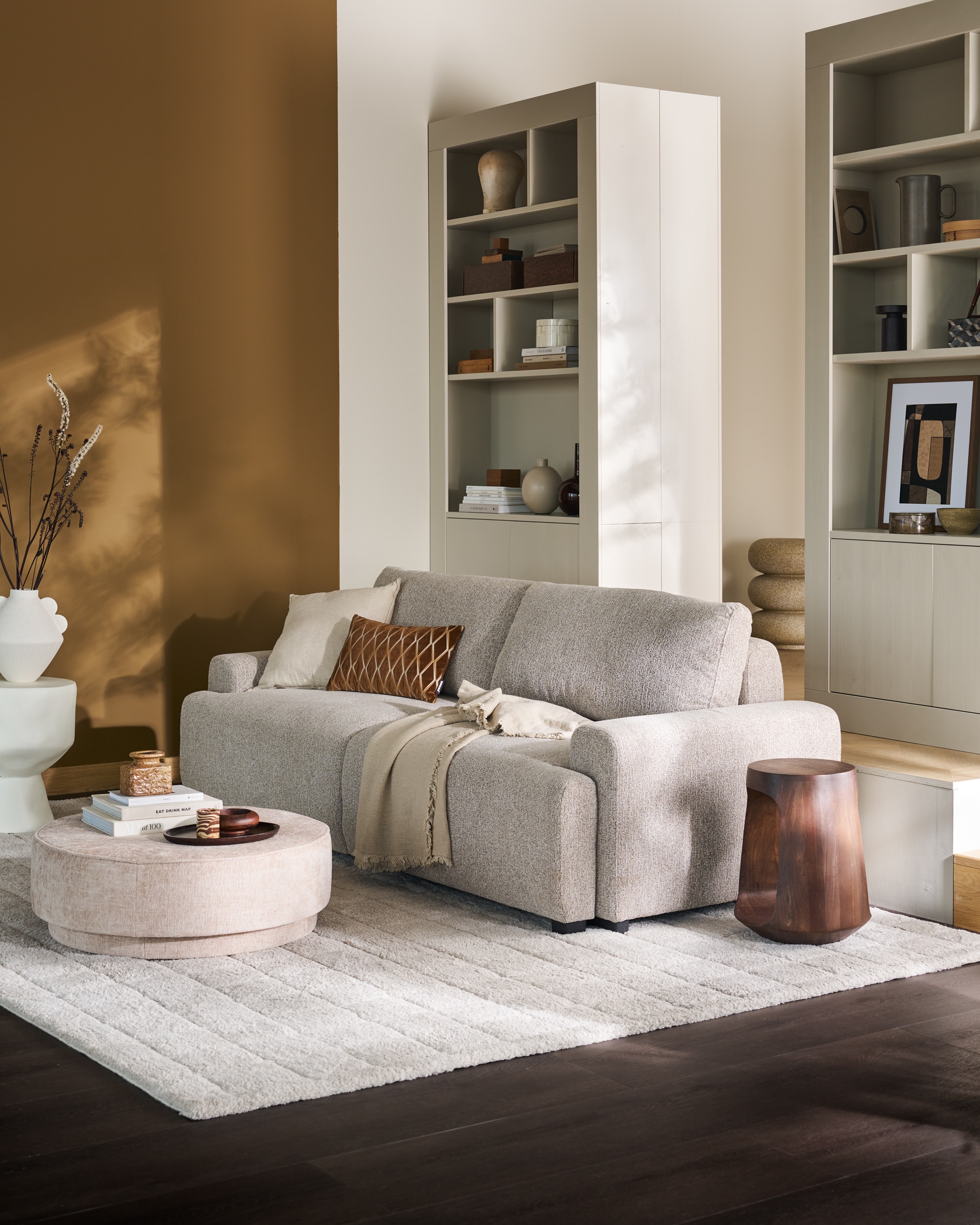 vtwonen wandkast Wallcover, grenen, dust, 117x31x229 cm (bxdxh), per stuk € 799,-, vtwonen 3-zitsslaapbank Night&Day, Pes, naturel melange, 239x107x85 cm (bxdxh), uitgeklapt 239x145x85 cm (bxdxh)€ 1349,-, vtwonen poef Pearl XL, melange stof, naturel, 80x28 cm (Øxh)€ 199,-.M.m.v. woood.nl (bijzettafels, kussen met dessin), weldaad.com (linnen kussen), vansand.nl (Little Greene muurverf Light Bronze Green no. 123), urbannatureculture.com (witte vaas), burbriantiek.nl (archiefdozen), ilsevanstoltz.com (art prints), yumeko (dekbedovertrekset).  Vloerkleed Blocks van vtwonen (shop.vtwonen.nl). Overig privébezit. vtwonen 11-2025 | styling Cleo Scheulderman | fotografie Jeroen Van der Spek