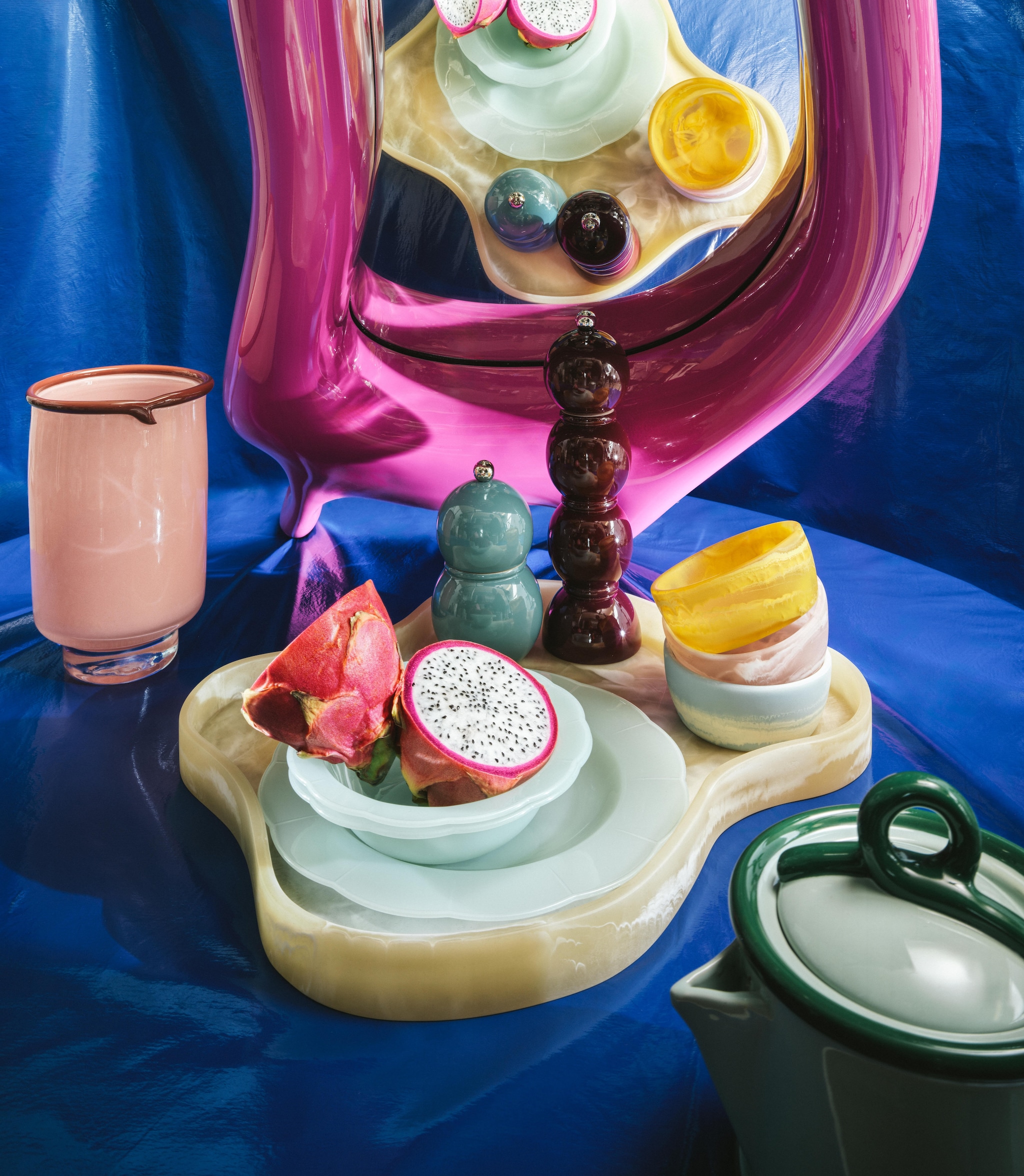 Polspotten wandspiegel Melting Mirror, large, roze, 103 cm (h) € 580,- (polspotten.com). Addison Ross peper-en-zoutstel Bobbin, gelakt hout, vanaf € 63,-, HKliving dienblad Patio, resin, beige € 89,-, dipschaaltjes Patio, resin polyester, in yellow, pale blue en blush € 17,- (debijenkorf.nl). &Klevering theepot Loop, groen, keramiek, 21x13,5x19 (bxdxh) cm € 45,- (klevering.com). Søstrene Grene vaas, koraal/rood, glas, 13x20 cm (Øxh) € 21,40, herbruikbare borden, polypropyleen, dusty green, set van 4 € 5,46, herbruikbare kommetjes, polypropyleen, dusty green, set van 4 € 3,78 (sostrenegrene.com). Kniphal stof, blauw (kniphal.nl). Stijlvol Wonen 10-2025 | Styling Djamilla van Brussel | fotografie Benning & Gladkova