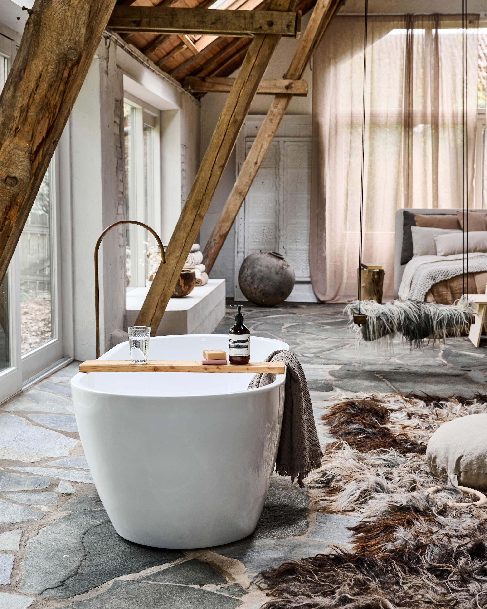 Bad Marktplaats. Gordijnen, vloerkleed, sprei, schommel, plaids Vacht van Vilt. Deur en vloervaas antiek. Bed Tuur. Kussens Casa comodo. Badplank via houthandel Lippold bouw. Houten schaal uit Indonesië. vtwonen 12-2025 | styling Marianne Luning | fotografie Sjoerd Eickmans