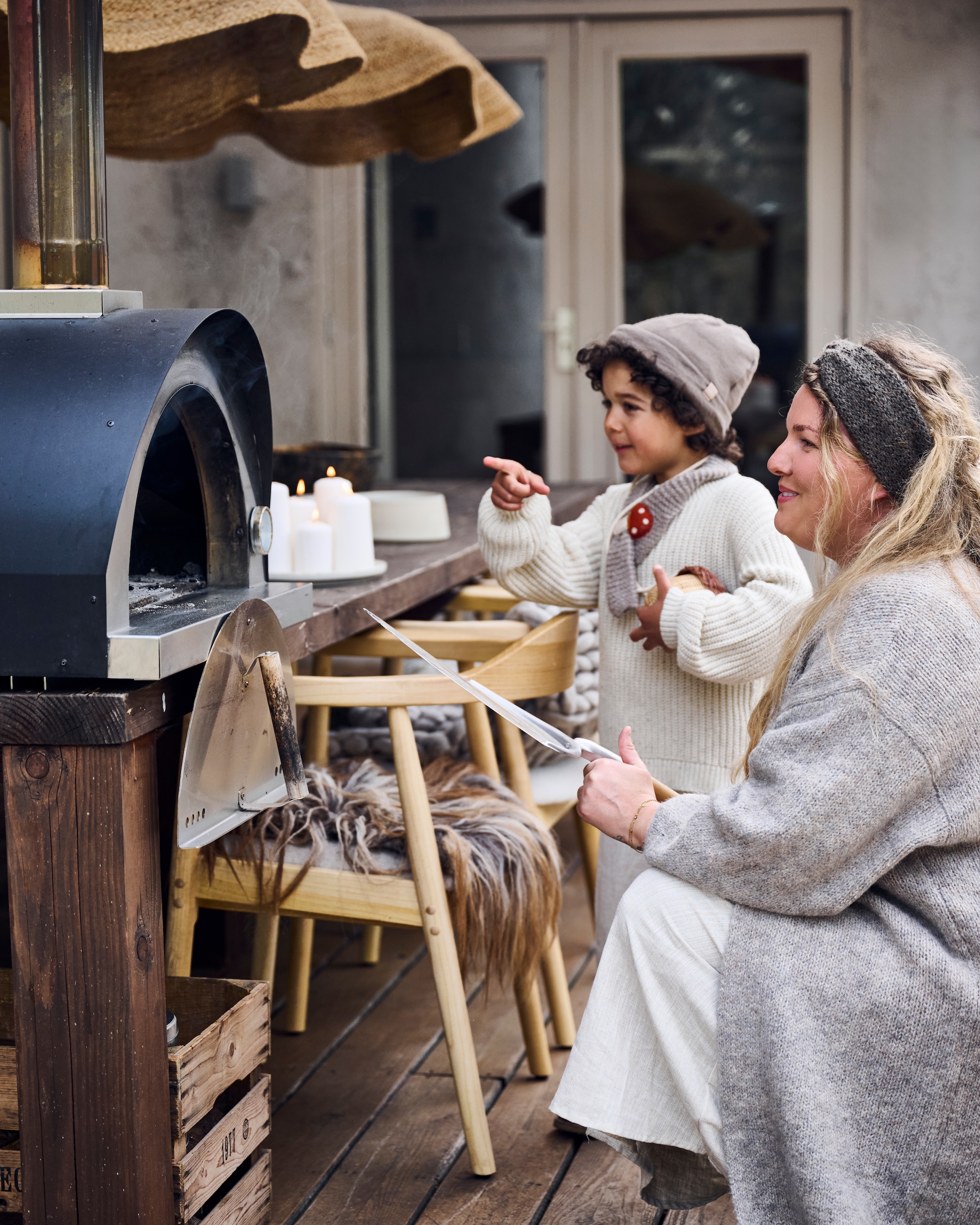 Oven Beek pizzaovens. Tafel Inouthout. Stoelkussens en rieten hanglamp Vacht van Vilt. vtwonen 12-2025 | styling Marianne Luning | fotografie Sjoerd Eickmans