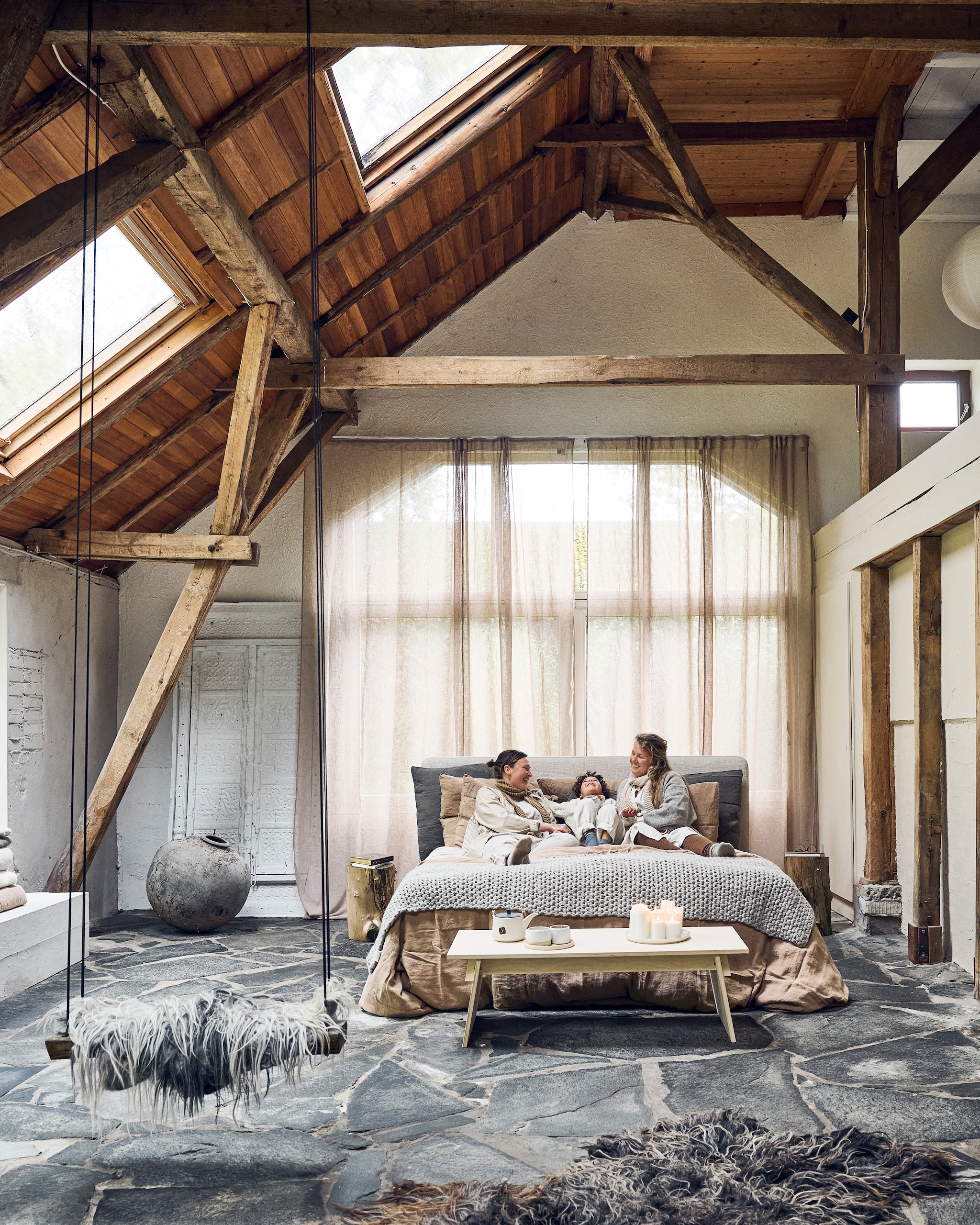 Bijzettafel voeteneind Fuyu van Grimm’s. Bijzettafels naast bed boomstammen uit eigen tuin. Theepot kringloop. Kopjes Akm keramiek. Kaarsen Ikea. vtwonen 12-2025 | styling Marianne Luning | fotografie Sjoerd Eickmans