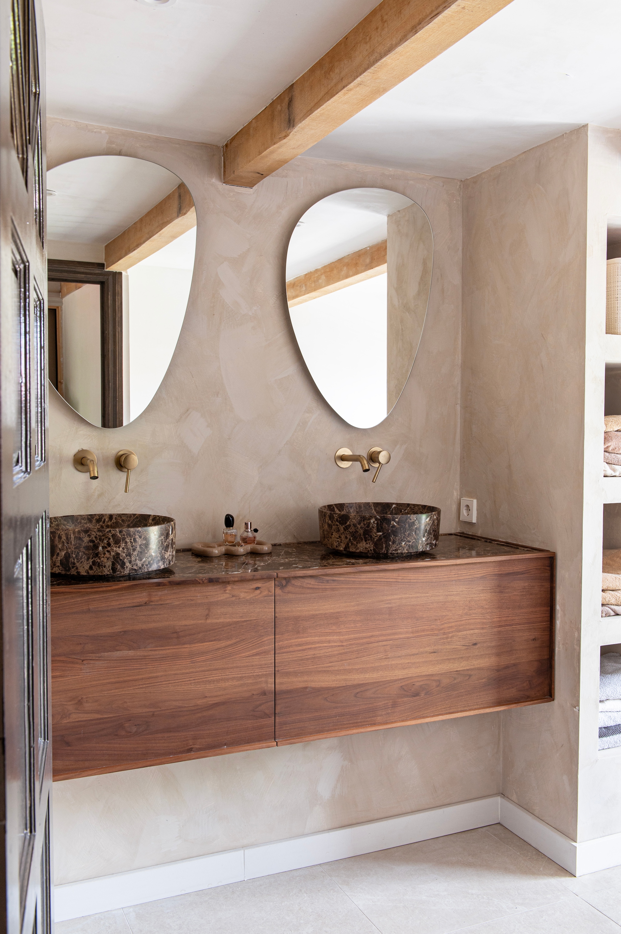 Spiegel Ben Organic van Saniweb. Wastafelmeubel Quadro notenhout en waskommen Fato van Balmani. Kranen Calvi van FortiFura. Wandafwerking kalkverf Monoliet van Betonstunter.  vtwonen 12-2025 | styling Jeske Weel | fotografie Caroline Coehorst