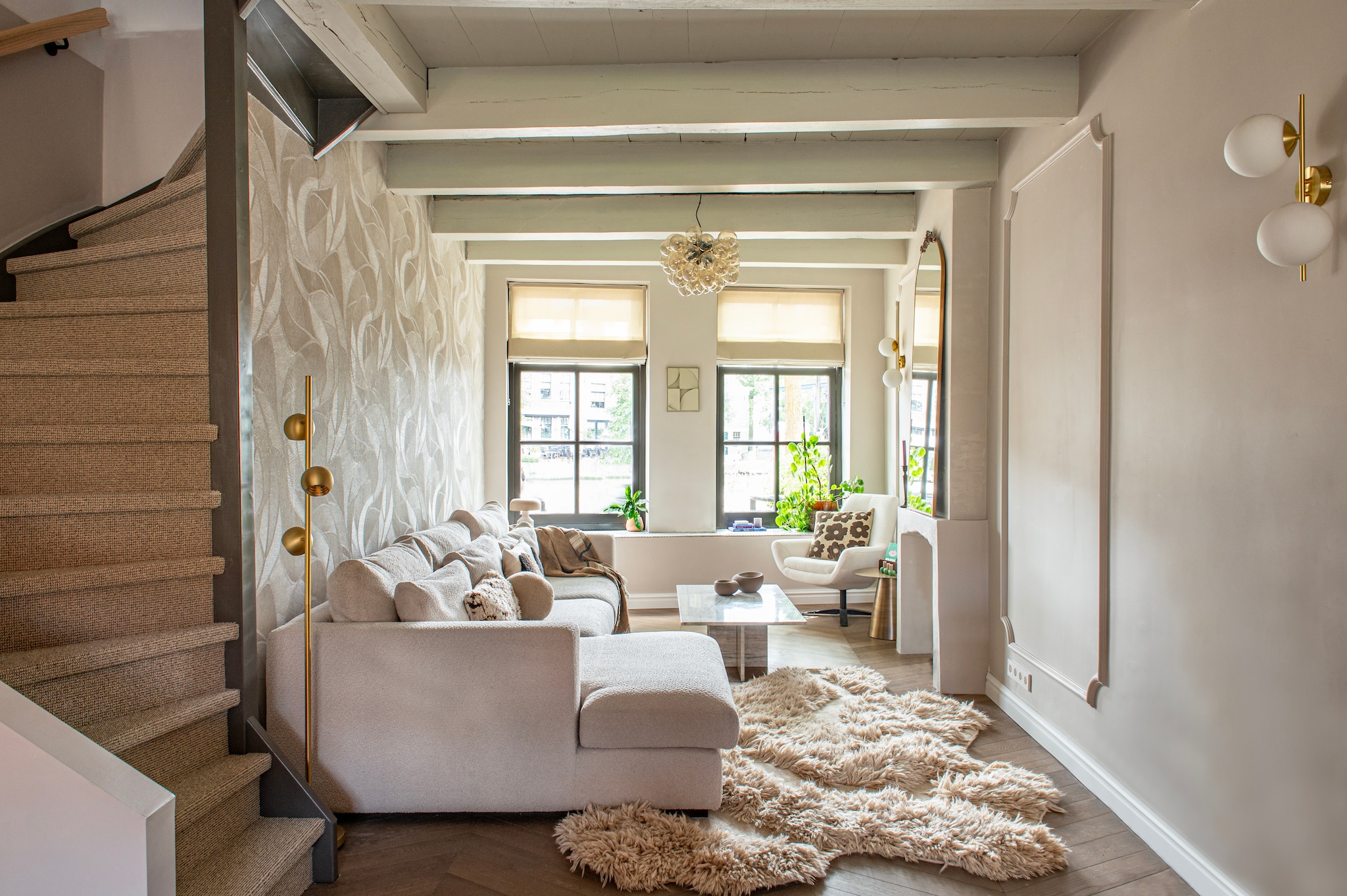 Vloerlamp 74194 van Rietveld Licht. Bank Haco. Vloerkleed The James. Spiegel Saida van Westwing. Wandlampen Mahala van Kave Home. Bijzettafel Mastic via Max Wonen. Sierlijst Het Schippertje. Verfkleur muur Intuitive van Histor. Verfkleur plafond onbekend. vtwonen 12-2025 | styling Jeske Weel | fotografie Caroline Coehorst