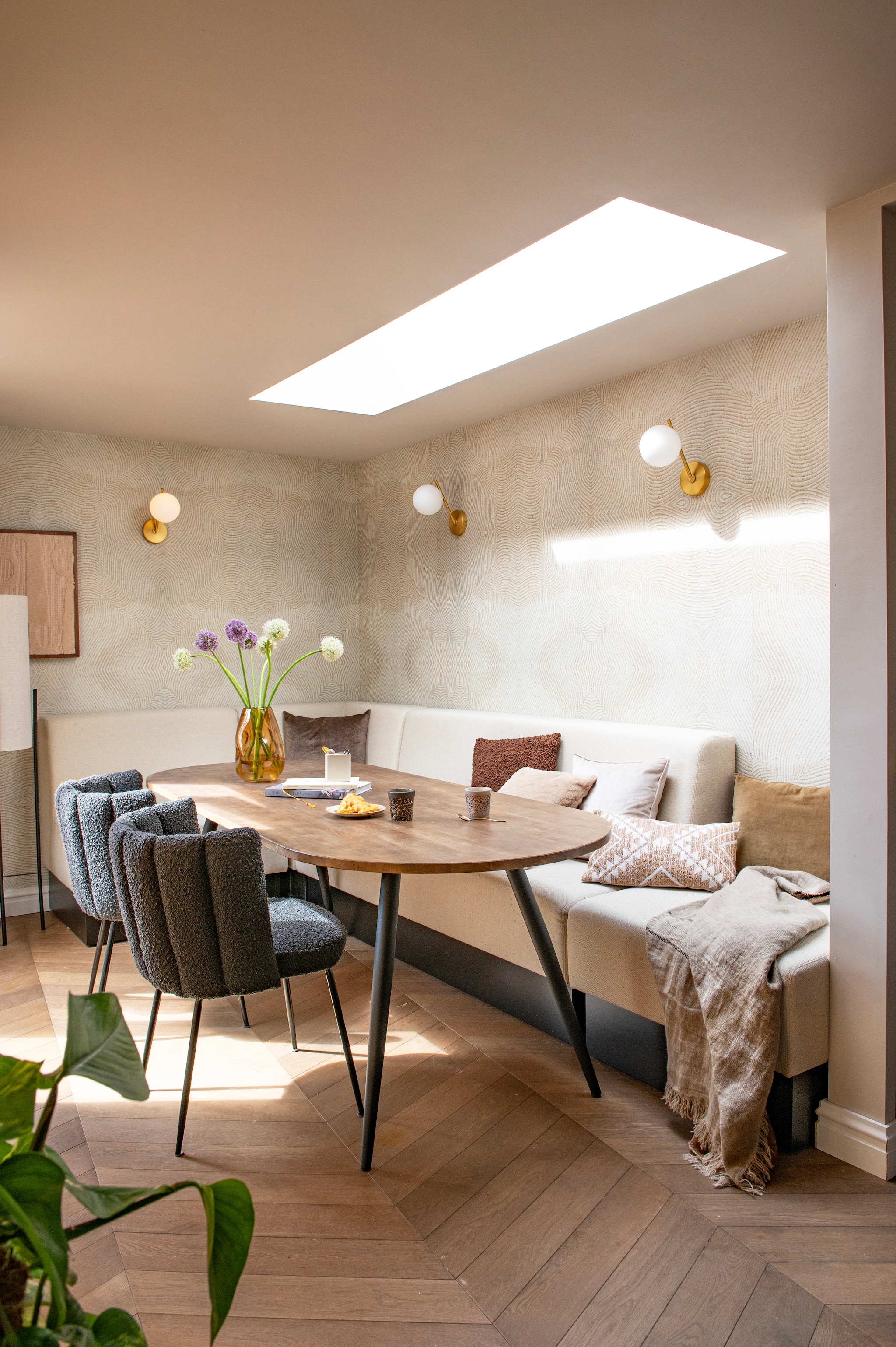 Bank op maat gemaakt. Kussens Wehkamp. Plaid The James. Eettafel Tablo van Woood. Stoelen Aniela van Kave Home. Kopjes HKliving. Vaas Loods 5. Kunstwerk Studio Livit. Vloerlamp Rich van Lampenlicht.  vtwonen 12-2025 | styling Jeske Weel | fotografie Caroline Coehorst