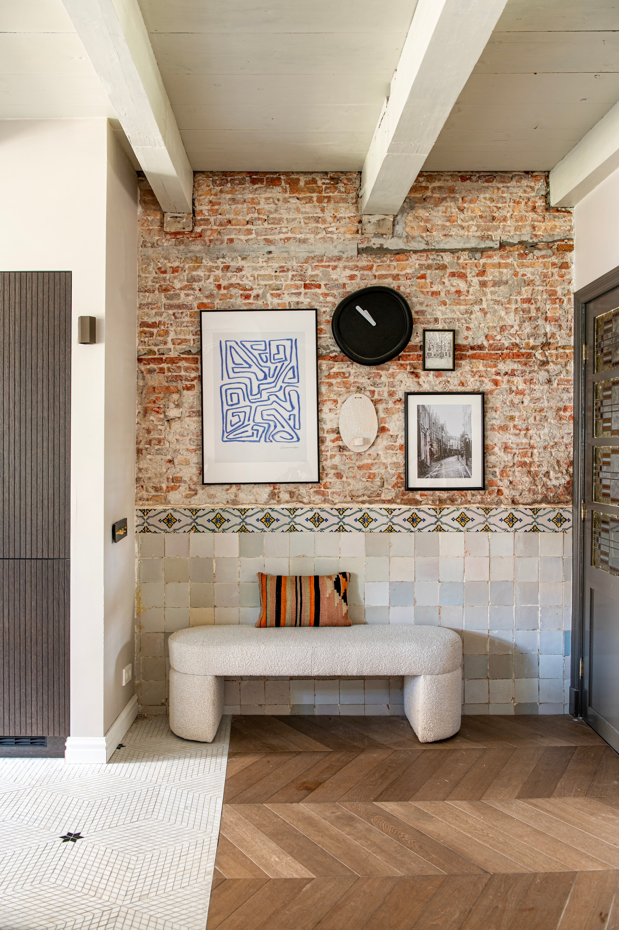 Bank Nice van Nous Living. Kussen The James. Klok Round Clock van Werkwaardig. Kunstwerk links Un Ornament Bleu Canvas van Desenio. Foto rechts Werk aan de Muur. Wandlamp Hexo Wall mini van Wever & Ducré. vtwonen 12-2025 | styling Jeske Weel | fotografie Caroline Coehorst