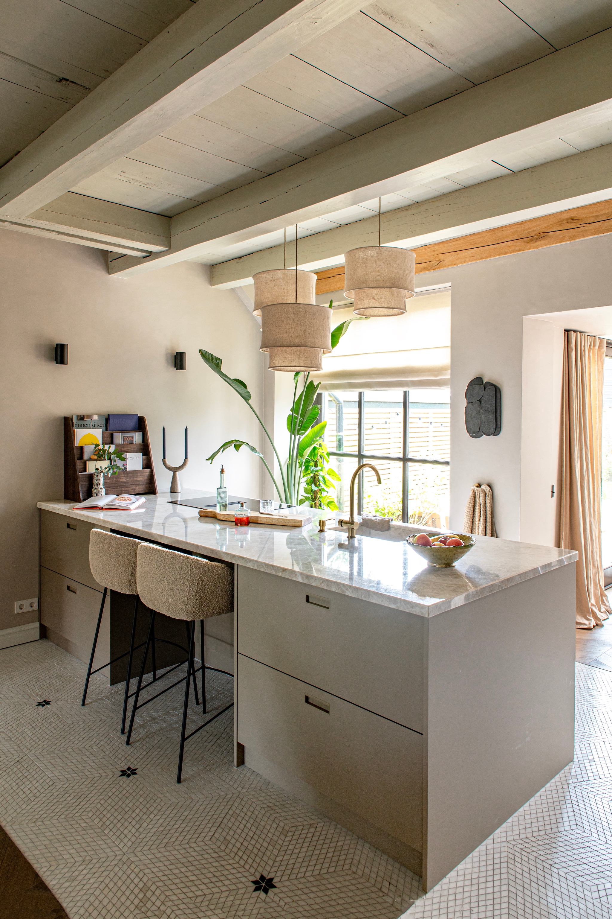 Vloer Mosaic Diamond Dolomit White van Designtegels. Wandlampjes Intoled. Boekenrek Amazon. Marmeren kandelaar Rif van Nordal. Kunstwerk H&m Home. Vouwgordijn Angelika en plooigordijn Lipalu van 123jaloezie. vtwonen 12-2025 | styling Jeske Weel | fotografie Caroline Coehorst