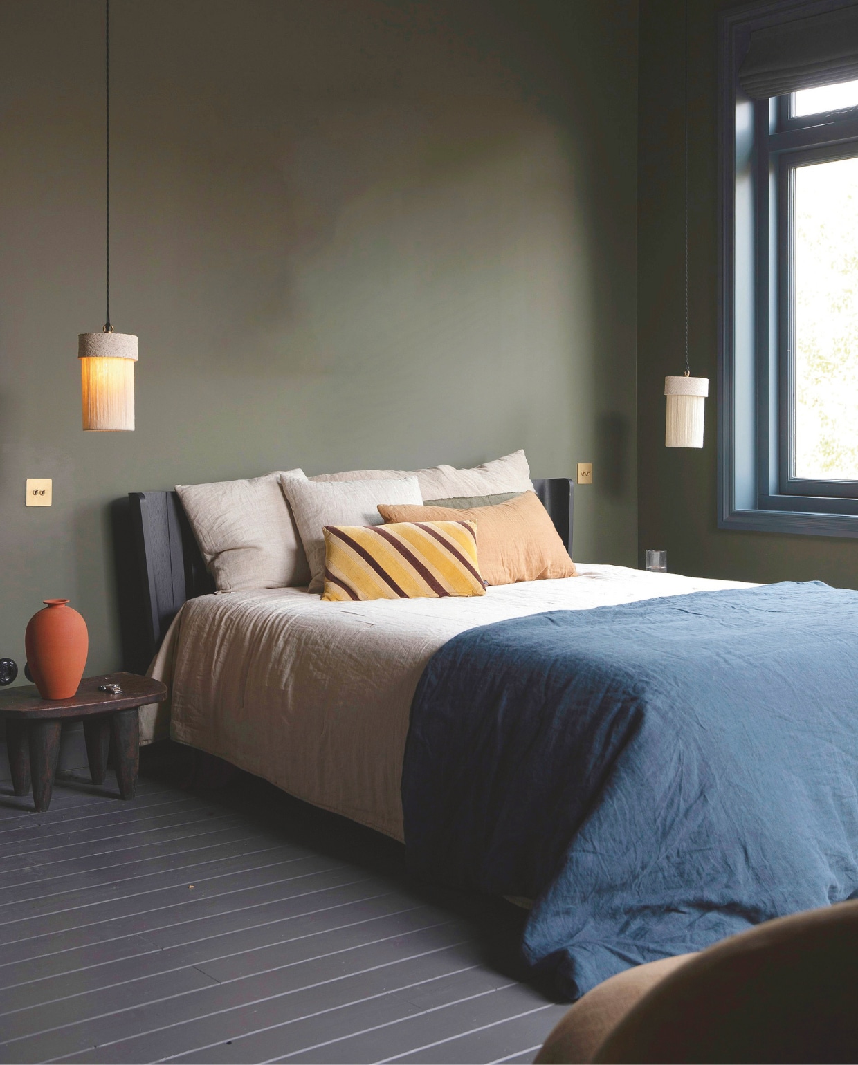 Kleur muren en plafond Lush Bean van Flexa Pure, kleur vloer 85% Grafiet van Flexa, kleur kozijn Nice Night van The Nice Stuff Colours by Flexa x Karwei. Bed Auping, bedlinnen en effen kussens By Mölle, kussen met strepen en vaas HKliving. Hanglampen woonwinkel in Parijs, schakelaar Corston. vtwonen binnenkijken 09-2025 | styling en fotografie Theo Bert-Pot, Jelle van de Schoor | tekst Britte Kramer