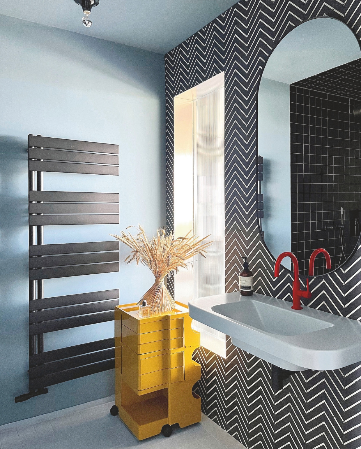 De tegels in de badkamer zijn van Villeroy & Boch. De grafische cementtegels zijn van Marrakech Design. De trolley die dienstdoet als wastafelkastje is een klassieker van Joe Colombo. Stijlvol Wonen 8-2025 | Styling & Fotografie Bart Wigger | Tekst Evelien Roels