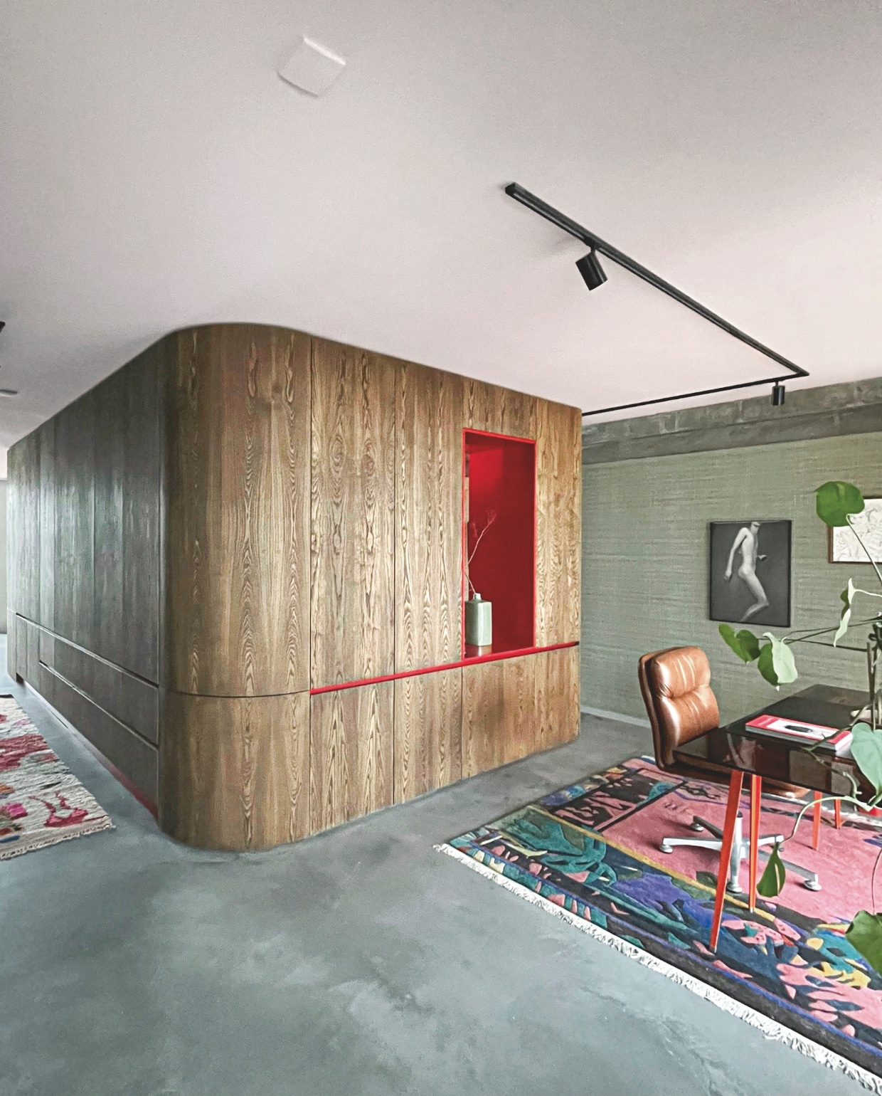 De grote L-vormige kastenwand heeft een uitsnede, waardoor je vanaf de bank op de Euromast uitkijkt. Het behang is van Lelièvre. De meubels waren al in het bezit van de bewoner. Stijlvol Wonen 8-2025 | Styling & Fotografie Bart Wigger | Tekst Evelien Roels