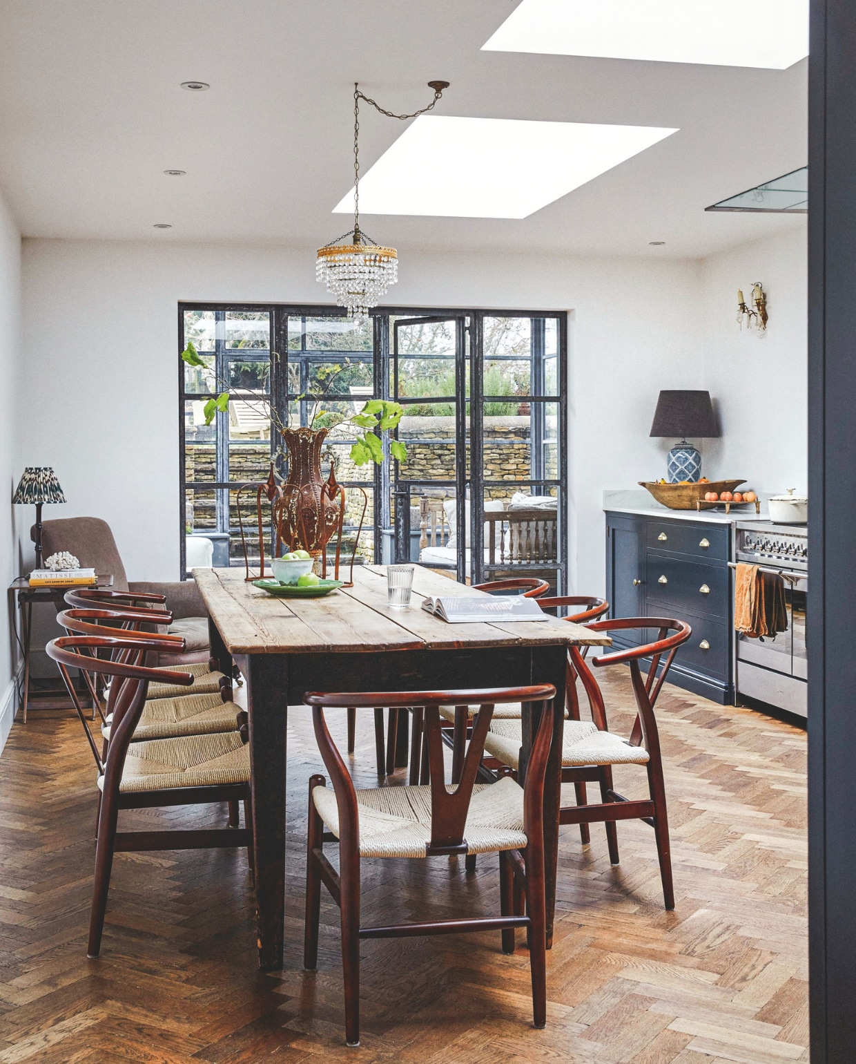 Vloer The Natural Wood Floor Company. Tafel van Tallboy Interiors via Ebay. Stoelen Wayfair. Fauteuil van veiling, bekleed met linnen van The Cloth Shop. Keukenkasten, werkbladen en planken Evie Willow. Grote tafellamp Där Lighting, kleine tafellamp Pooky. Kroonluchter van antiekmarkt. Accessoires en Decoratie Article 3 Interiors. vtwonen Landelijk 9-2025 | fotografie Brent Darby | tekstbewerking Anneleen Peeters