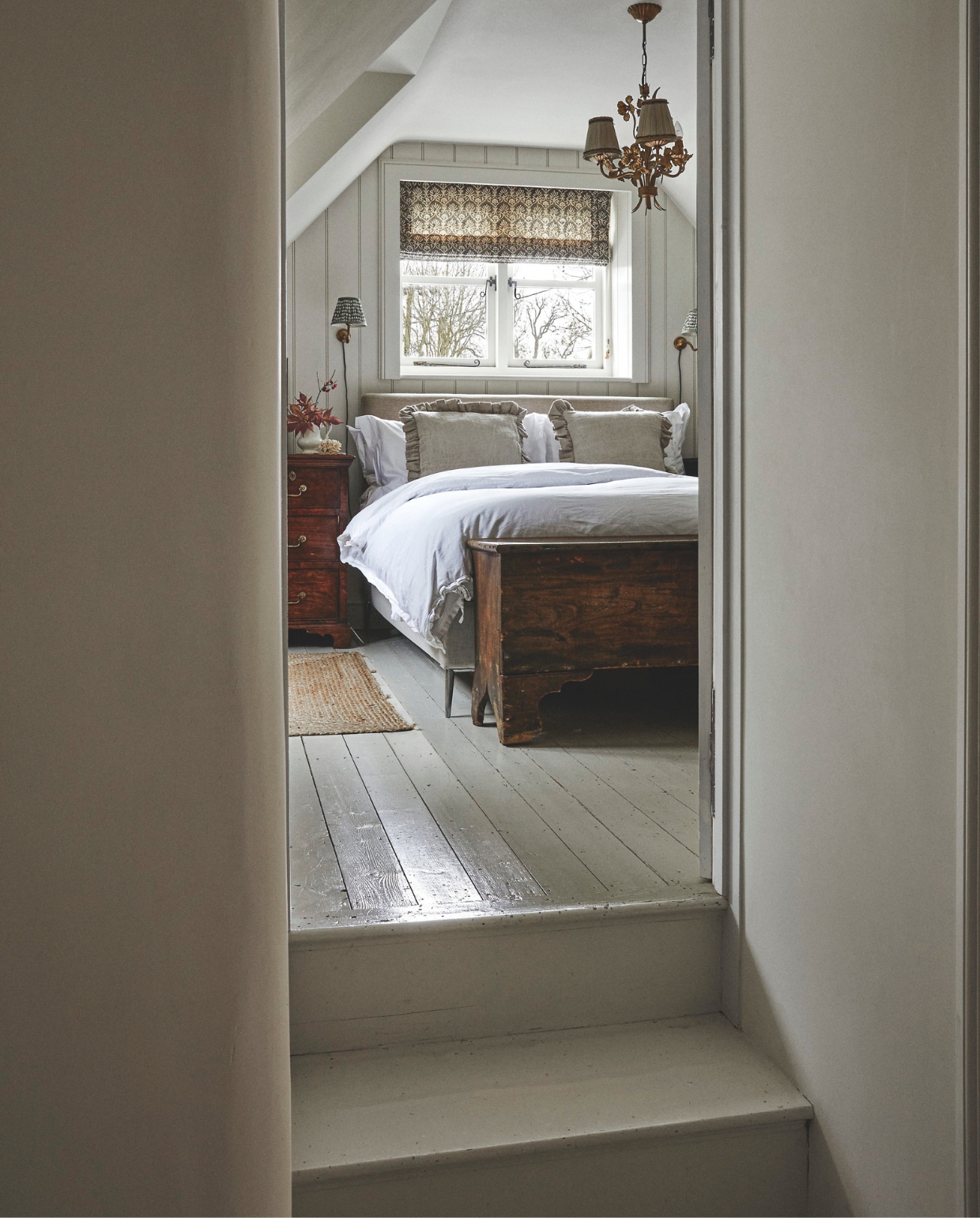 Bed And So To Bed. Beddengoed The White Company. Wandlampen Pooky. Vouwgordijn The Cloth Shop. Kroonluchter uit tweedehands-winkel. Kist van veiling.  Muurverf Shaded White van Farrow & Ball. vtwonen Landelijk 9-2025 | fotografie Brent Darby | tekstbewerking Anneleen Peeters
