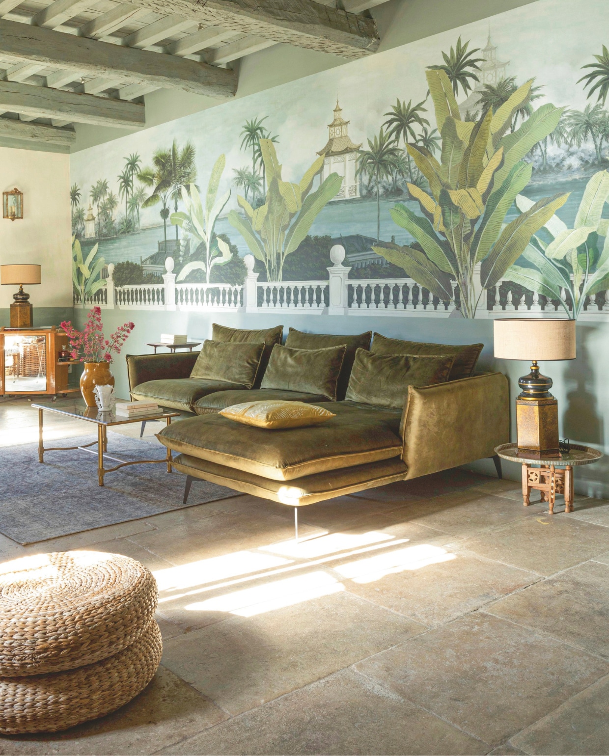 De grote woonkamer in het privégedeelte van het huis. Panorama-behang van Ananbô. Vloer van stenen uit de steengroeves van Montpellier, fluwelen bank van Atzana in Uzès en oosterse bijzettafels. vtwonen Landelijk 8-2025 | styling Laura Taccari | fotografie Monica Spezia | tekstbewerking Roel Janssen