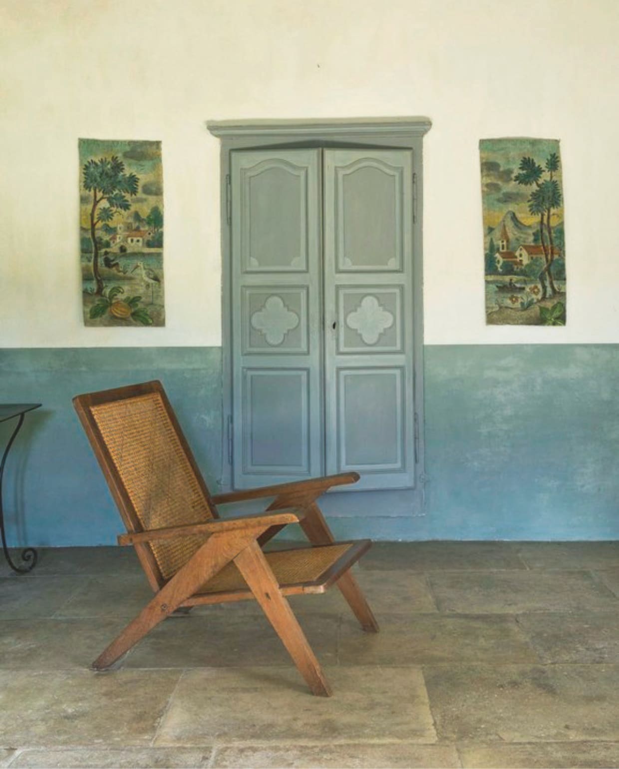 Het interieur is gevuld met meubels en objecten die ze door de jaren heen verzamelde op brocantemarkten in Frankrijk, zoals de smeedijzeren tafel, rotan fauteuil en wereldbol. vtwonen Landelijk 8-2025 | styling Laura Taccari | fotografie Monica Spezia | tekstbewerking Roel Janssen
