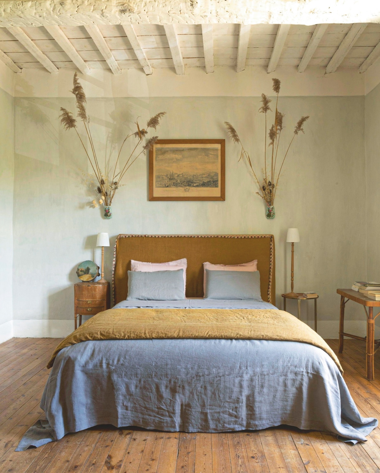 Cognackleurig linnen hoofdbord van Bon Jour Uzès, beddengoed en kussenslopen van Society Limonta. Nachtkastje en handgeschilderde tamboerijn vintage. vtwonen Landelijk 8-2025 | styling Laura Taccari | fotografie Monica Spezia | tekstbewerking Roel Janssen