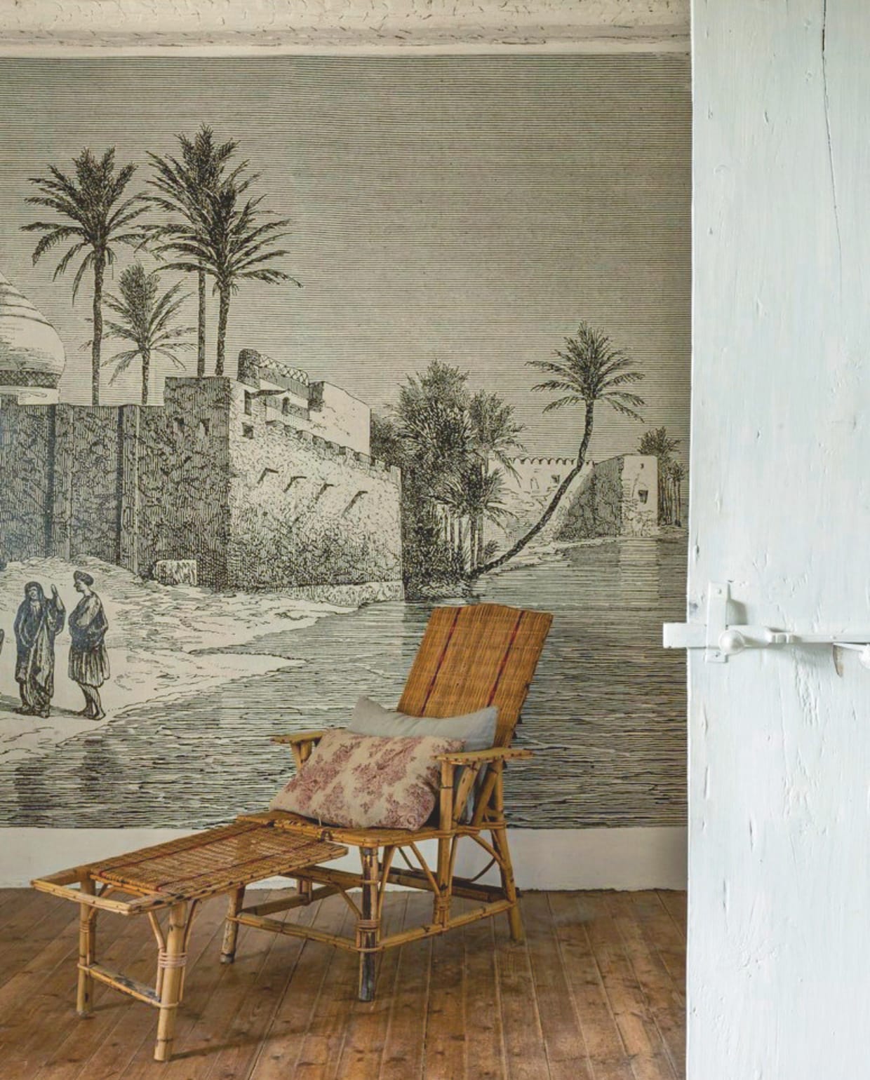 De slaapkamer met panoramabehang Les Papiers van Ninon. Vintage rotan fauteuil. vtwonen Landelijk 8-2025 | styling Laura Taccari | fotografie Monica Spezia | tekstbewerking Roel Janssen