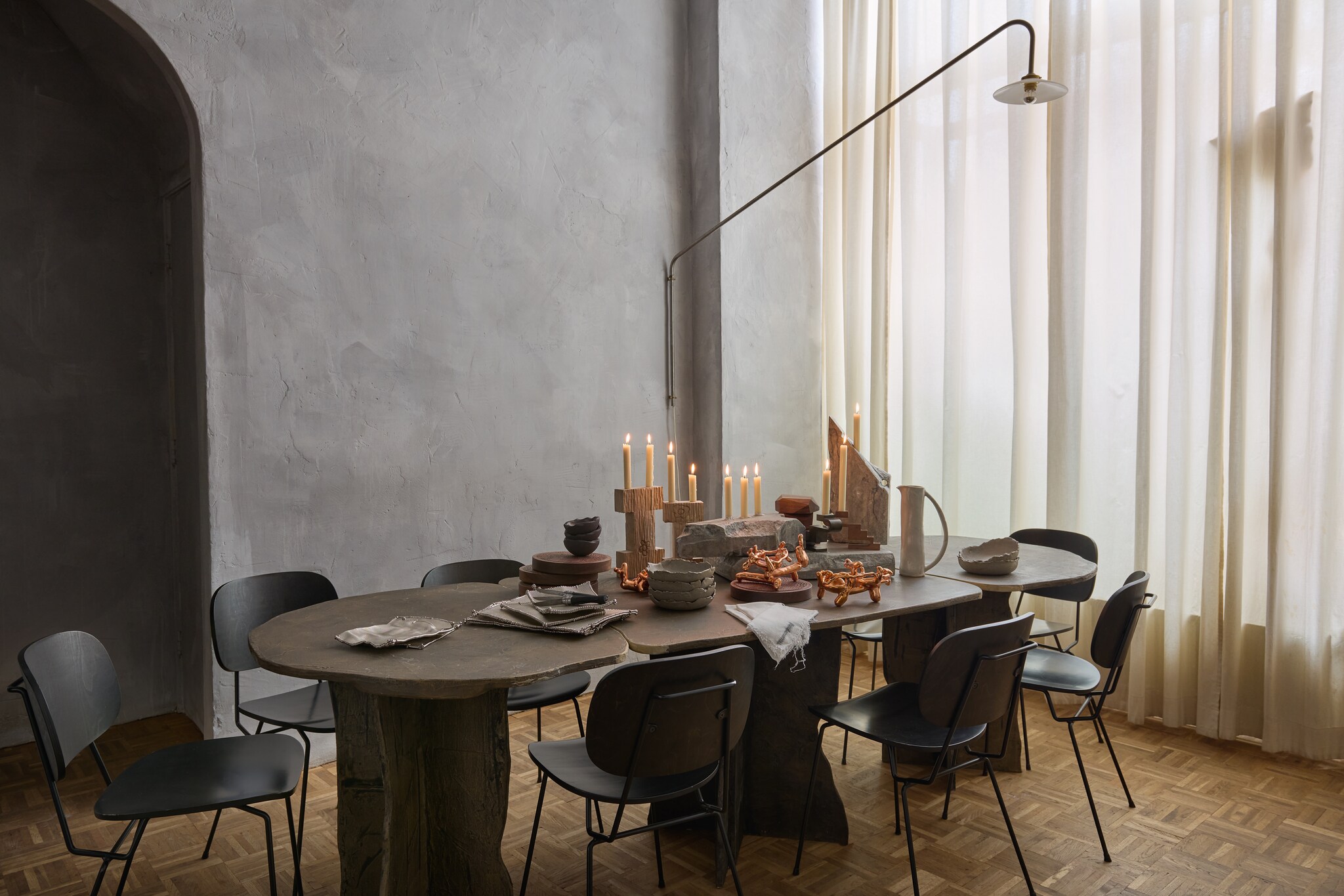 Lamp Muller Van Severen voor Valerie Objects. Stoelen Lensvelt. Tafel eigen ontwerp Fundamental Objects. Muurafwerking eigen recept van stuc, klei en kalkverf. Gordijnen onbewerkt katoen. Schenkkan Pasella. Koperen objecten voor amuses Audrey Large. Kandelaars links Frank Penders. Servies Merging Matter. Servetten van kaasdoek eigen ontwerp. Plateaus verchroomd Odd Matter. stijlvol wonen 10-2025 | styling Tamara Botter | fotografie Kasia Gatkowska