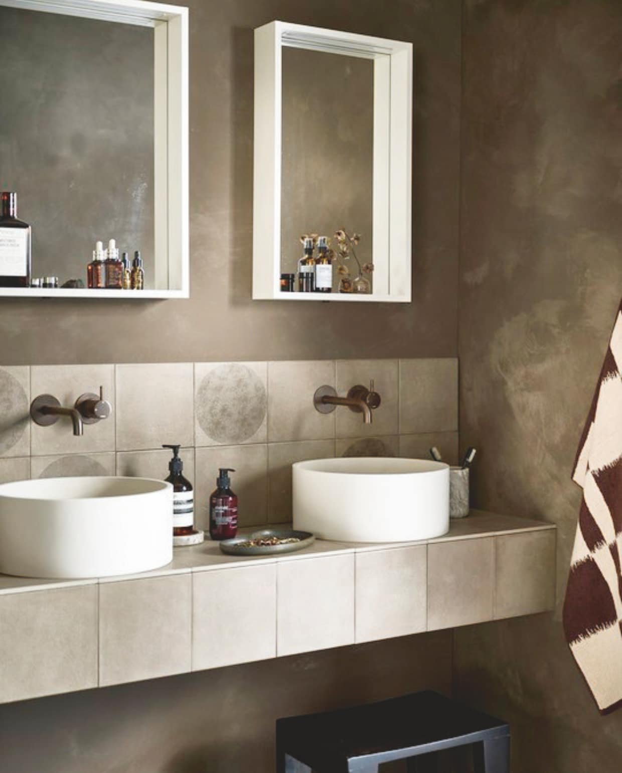 Kunststof spiegels Gorgeous in matzand, met ledverlichting, 60x10x65 cm (bxdxh) € 491,- en 40x10x65 cm (bxdxh) € 454,-, ook verkrijgbaar in wit, zwart en grijs. Top solid waskommen Circle in matzand, 37x15 cm (Øxh), per stuk € 497,-, ook verkrijgbaar in matzwart, grijs en wit. Wastafel betegeld met wandtegel Earth Argilla, 20x20 cm, per m² € 54,50 en wandtegel Earth Argilla Cirkel Decor, 20x20 cm, per m² € 64,50. vtwonen 06-2024 | styling Kim van Rossenberg | fotografie Sjoerd Eickmans