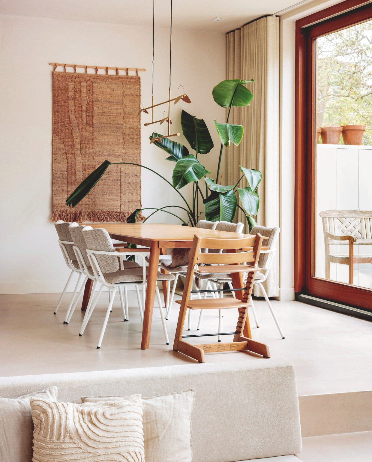 Wandkleed Ferm Living. Stoelen Bodilson via Mooi en Belle. Kinderstoel Tripp Trapp van Stokke. Tafel Loods 5. Lamp Bolia. Gordijnen lapjesmarkt Utrecht. Kussens H&M Home. vtwonen 10-2025 | fotografie Ernie Enkelaar | tekst Merel van der Lande