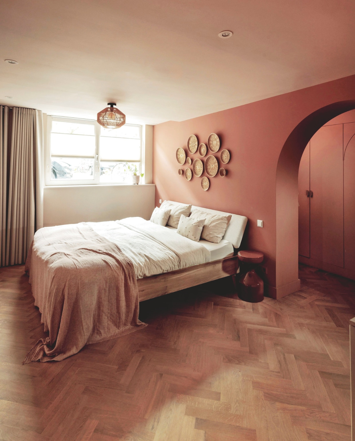 Muurkleur In The Buff, Light Cherry Parade en Sombrero Tan van Histor. Vloer De Houtfabriek. Plaid stof van lapjesmarkt. Bijzettafel Woood. Bed Swiss Sense.Dekbedovertrek en  kussen palmboom H&M Home. Rotan borden souvenirs uit Thailand. Gordijnen lapjesmarkt. vtwonen 10-2025 | fotografie Ernie Enkelaar | tekst Merel van der Lande
