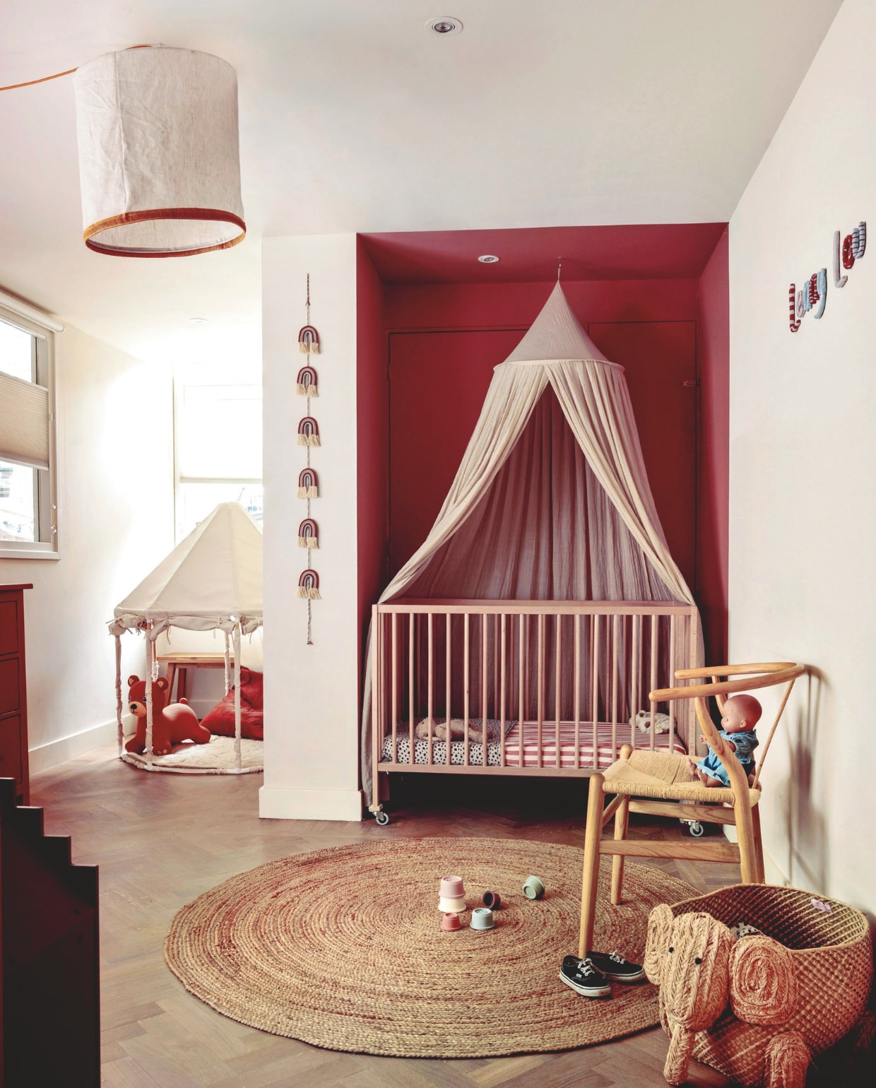 Muurkleur Singing Sand, in nis Sombrero Tan, beide Histor. Oude lamp gepimpt met band en gekleurd snoer. Bed Ikea. Stoel Sklum. Naam aan muur zelf gekleid. Klamboe Jollein. Vloer De Houtfabriek. Vloerkleed Boho & Me. vtwonen 10-2025 | fotografie Ernie Enkelaar