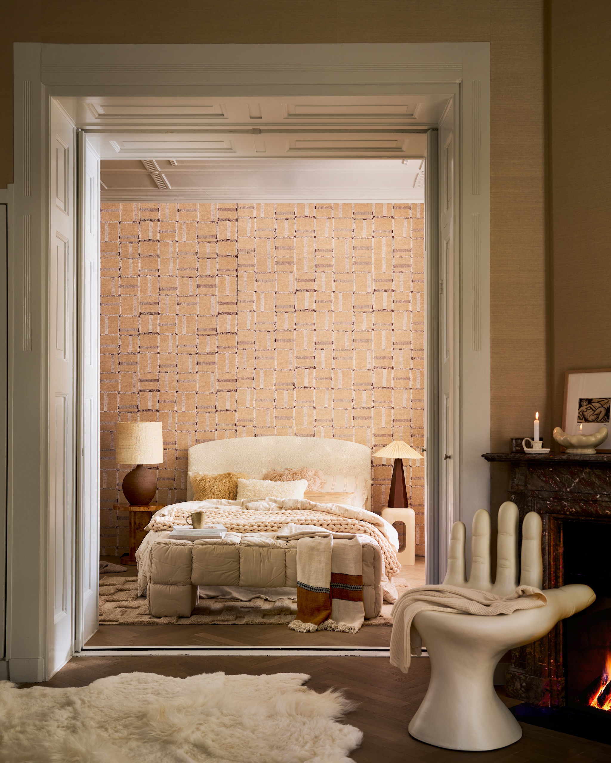 Élitis behang Cybele Portee par la Nature, VP100914, 70 cm x 10 m, per rol € 185,- (elitis.fr). HKliving bank Puffy Loby, katoen en mdf, pebble, 140x40x45 cm (lxbxh) € 425,-, schaal, glas, oyster € 49,99, tekening Suns Out, 37x29 cm (lxb) € 49,99 (hkliving.com). Best Wel Hip tafellamp, vintage, keramiek en jute, bruin € 645,-, hand-stoel, kunststof, ivoorwit € 1100,- (bestwelhip.nl). Momo Rugs vloerkleed Amalfi, lichtbruin, wol, 240x170 cm (lxb) € 895,- (vloerkledenwinkel.nl). Vachtenspecialist vloerkleden, schapenvacht, melange wit, 180x120 cm (lxb) € 695,-, kussen Tibet, lamsvacht, offwhite € 64,95 (vachtenspecialist.nl). Libeco deken Highland Stripe, linnen, beige en bruin, 220x140 cm (lxb) € 336,- (sukha.nl). Wolletjebol grove deken, hand-gebreid, katoen, zand, 140x90 cm (lxb) € 159,- (wolletjebol.nl). Dutchbone bijzettafel Quinn, wortelhout fineer met glanzende lak, 46x51 cm (Øxh) € 249,-, Zuiver bijzettafel Creek, kunststof, beige hoogglans, 29x29x48 cm (lxbxh) € 139,- (shop.vtwonen.nl). Zara Home gestreept dekbedovertrek, ecru bruin, linnen € 119,-, kussenslopen, zijde, set van 2 € 59,99, kussenhoes, bruin € 45,99, kussenhoes, teddy, ecru € 22,99, kandelaar, keramiek € 15,99 (zarahome.com). Dusty Deco tafellamp Hexagon, hout, 30x77 cm (Øxh) € 650,- (dustydeco.com). vtwonen 12-2025 | styling Cleo Scheulderman | fotografie Jeroen van der Spek