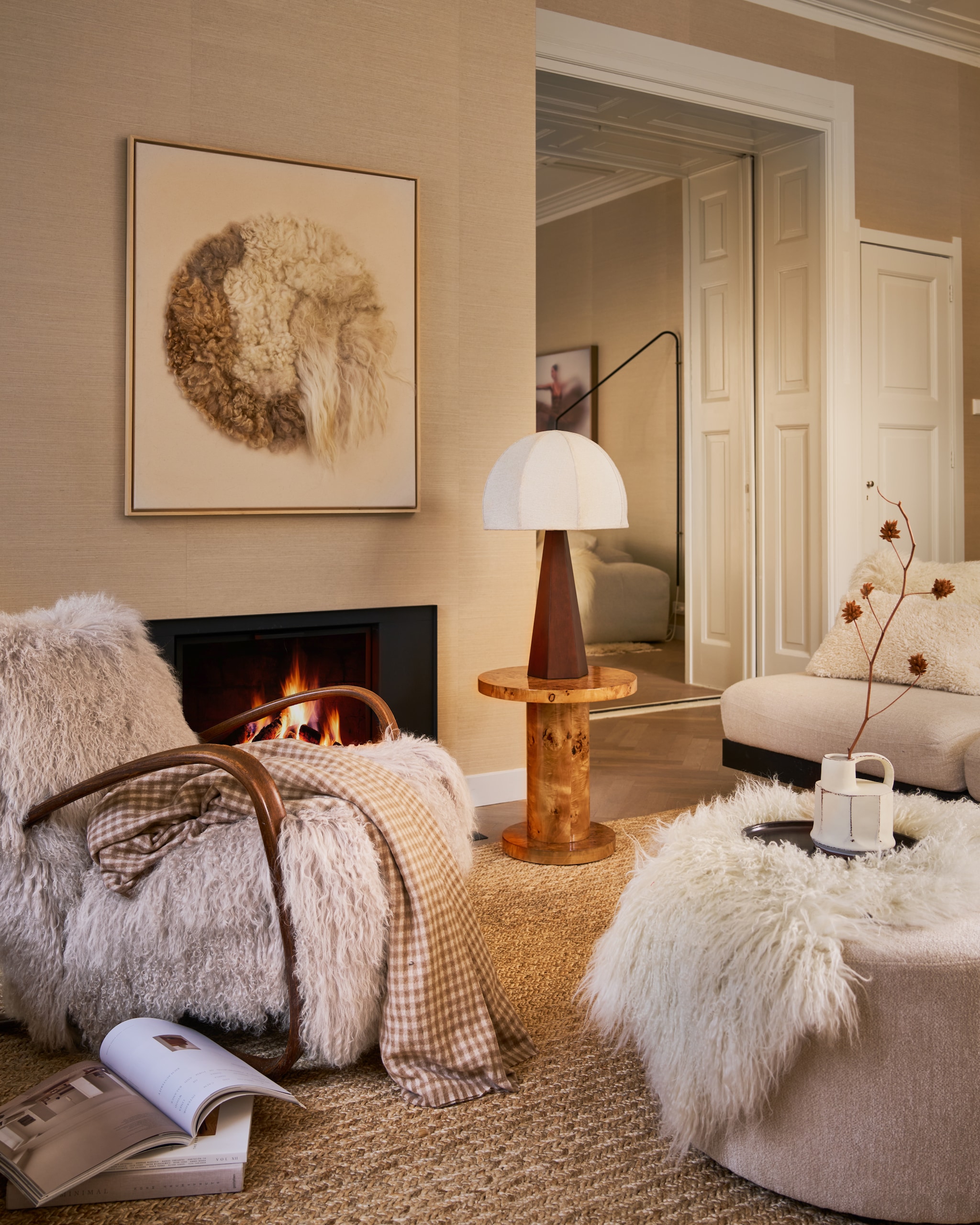 Best Wel Hip fauteuil Jindrich Halabala, vintage, met Tibetaanse schapenvacht, 66x92x77 cm (bxdxh) € 3850,- (bestwelhip.nl). Halona wandobject Moon framed13, Babette Leertouwer, gerecycled wol en katoen, 95x110 cm (lxb) €1495,- (halona.nl). Dutchbone bijzettafel Quinn, bruin, wortelhout fineer met lak, 46x51 cm (Øxh) € 249,-, poef Rocca, beige, polyester, 70x40 cm (Øxh) € 335,- (shop.vtwonen.nl). Dusty Deco tafellamp Hexagon, hout, crème, 30x77 cm (Øxh) € 650,- (dustydeco.com). Serax bank Rudolph van Vincent van Duysen, hout en bouclé, bone, 93x112x72 cm (bxdxh), per element € 3099,- (serax.com). Vachtenspecialist schapenvacht IJslands, op bank, wit € 79,95 (vachtenspecialist.nl). Momo Rugs vloerkleed Naurtex Rope Line, zand, 200x250 cm € 2325,- (vloerkledenwinkel.nl). Zara Home kussenhoes, teddy crème, 40x60 cm € 25,99, deken, beige/bruin geruit, 240x220 cm (lxb) € 59,99, vaas handvat, aardewerk, crème € 19,99, dienblad, donker hout € 17,99 (zarahome.com). vtwonen 12-2025 | styling Cleo Scheulderman | fotografie Jeroen van der Spek