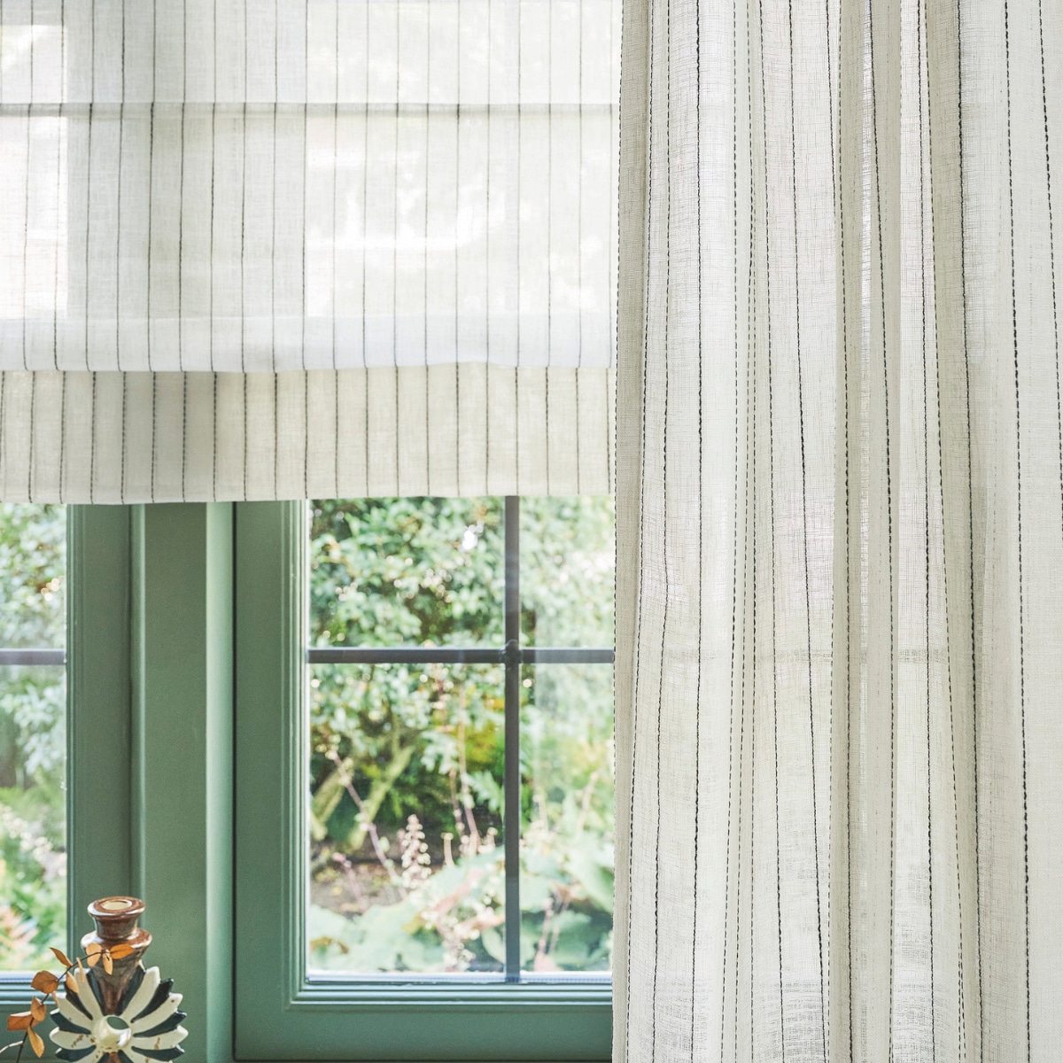 vtwonen vouwgordijn, lichtdoorlatende stof, wide stripe, ecru black stripe (nr. 2317), per meter vanaf € 28,99. vtwonen gordijn, lichtdoorlatende stof, wide stripe, ecru black stripe (nr. 2317), per meter vanaf € 28,99.M.m.v. zarahome.com (kandelaar, schaal, koffietafelboek), boisblanchome.com (hanglamp). Overig privébezit. vtwonen 10-2025 | styling kim van rossenberg | fotografie sjoerd eickmans