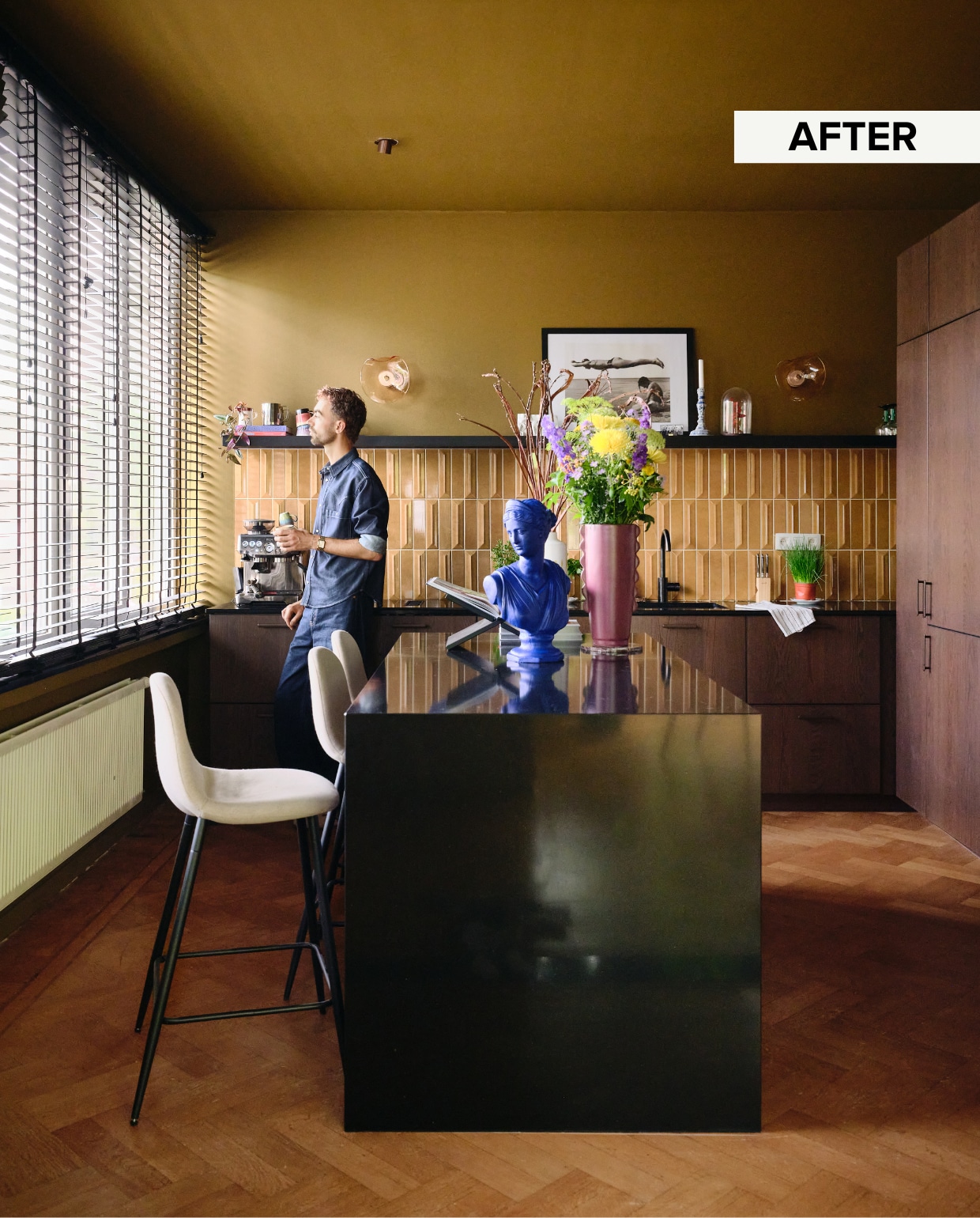 Keuken van walnoothout en graniet Ikea, bronzen spots Qazqa, 3D-tegels RG Tegel, vaas Maisons du Monde, blauw beeld Marktplaats, poster Erik Tonen Books, wandlampen Lampslightsandco, verfkleur Autumn Gold van Flexa. Vergelijkbare barkrukken Home Deco Factory. vtwonen 10-2025 | fotografie Mr. Frank