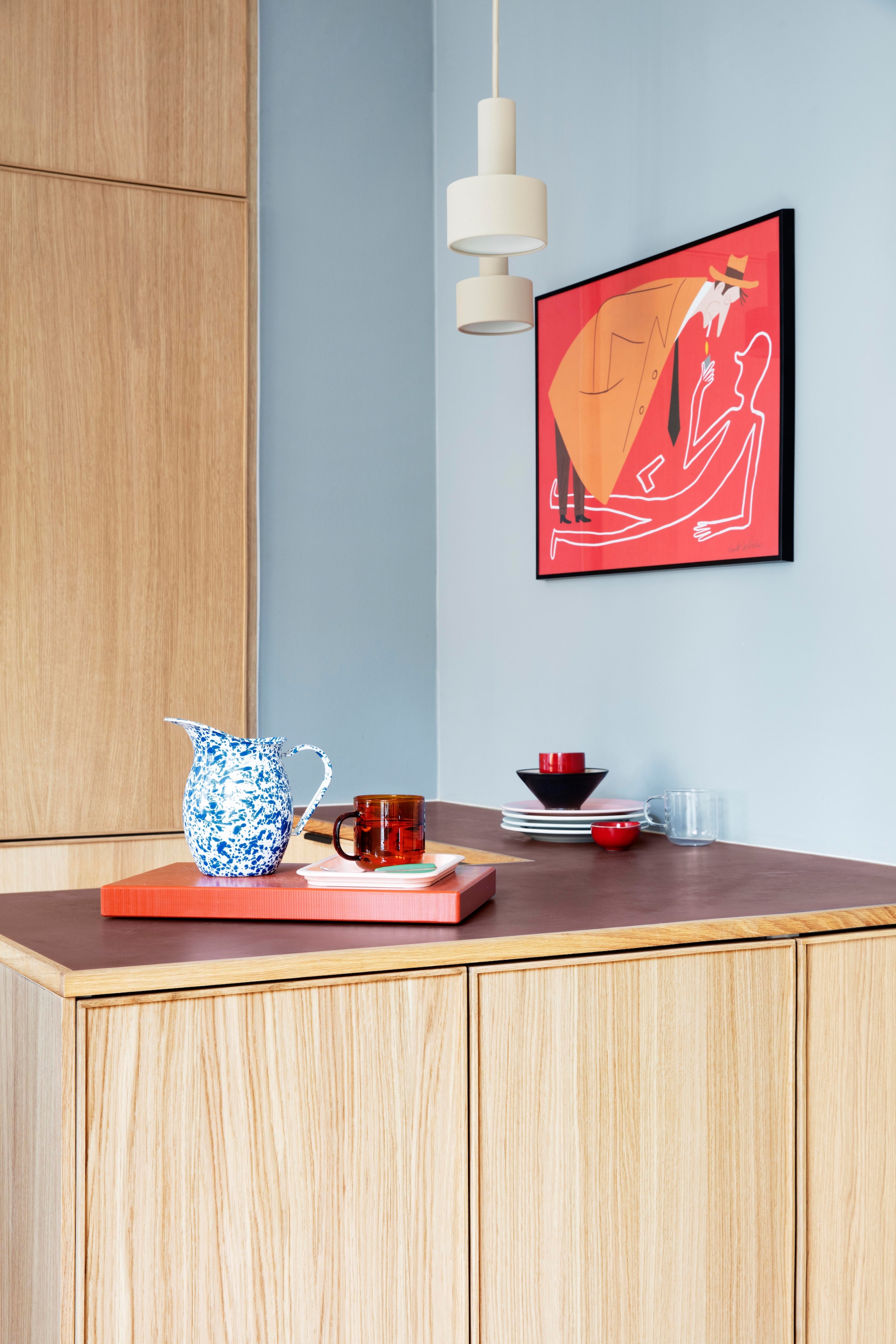 Linoleum werkblad Forbo. Lampen Collect Lighting van Ferm living. Illustratie Bendik Kaltenborn. Kan shop Dora. Rode beker en dienblad Hay. Roze schaaltje Søstrene Grene. Houten lepel rommelmarkt. vtwonen 01-2026 | productie Living Inside | styling Rikke Graff Juel | fotografie Christina Kayser O.