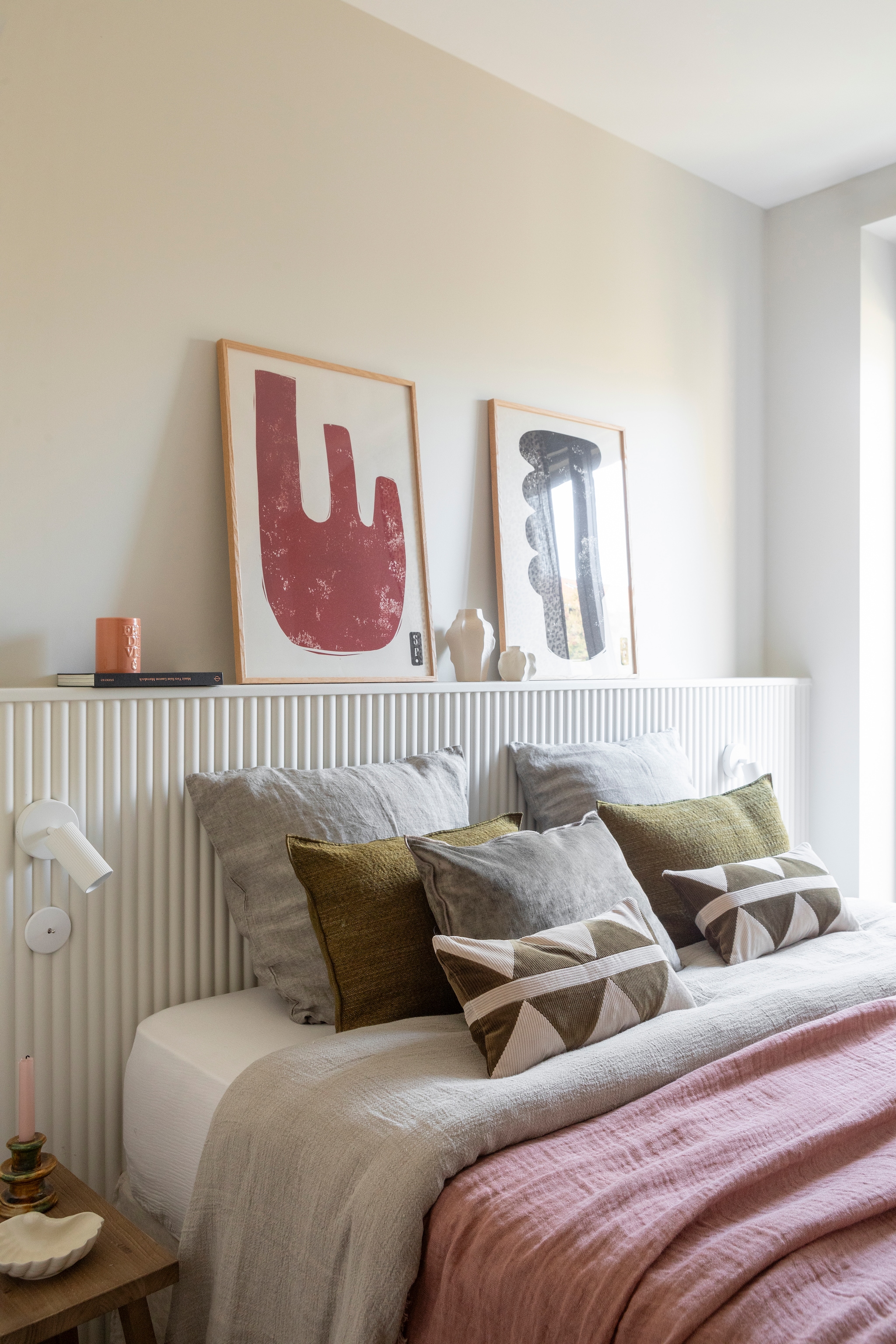 Muurverf Blanc de Meudon van Argile Peinture. Hoofdeinde in polymeer geverfd in Blanc de Meudon van Argile peinture. Kunstwerken Paper Collective. Kleine vazen H&m Home. Kleine opaline lamp Vanity Boum. Leeslamp La Redoute. Nachtkastje Zara home. Kussen Minos Army van Élitis.  vtwonen 01-2026 | styling Marie Maud Levron | fotografie Pierrick Verny | productie AC Scoffoni