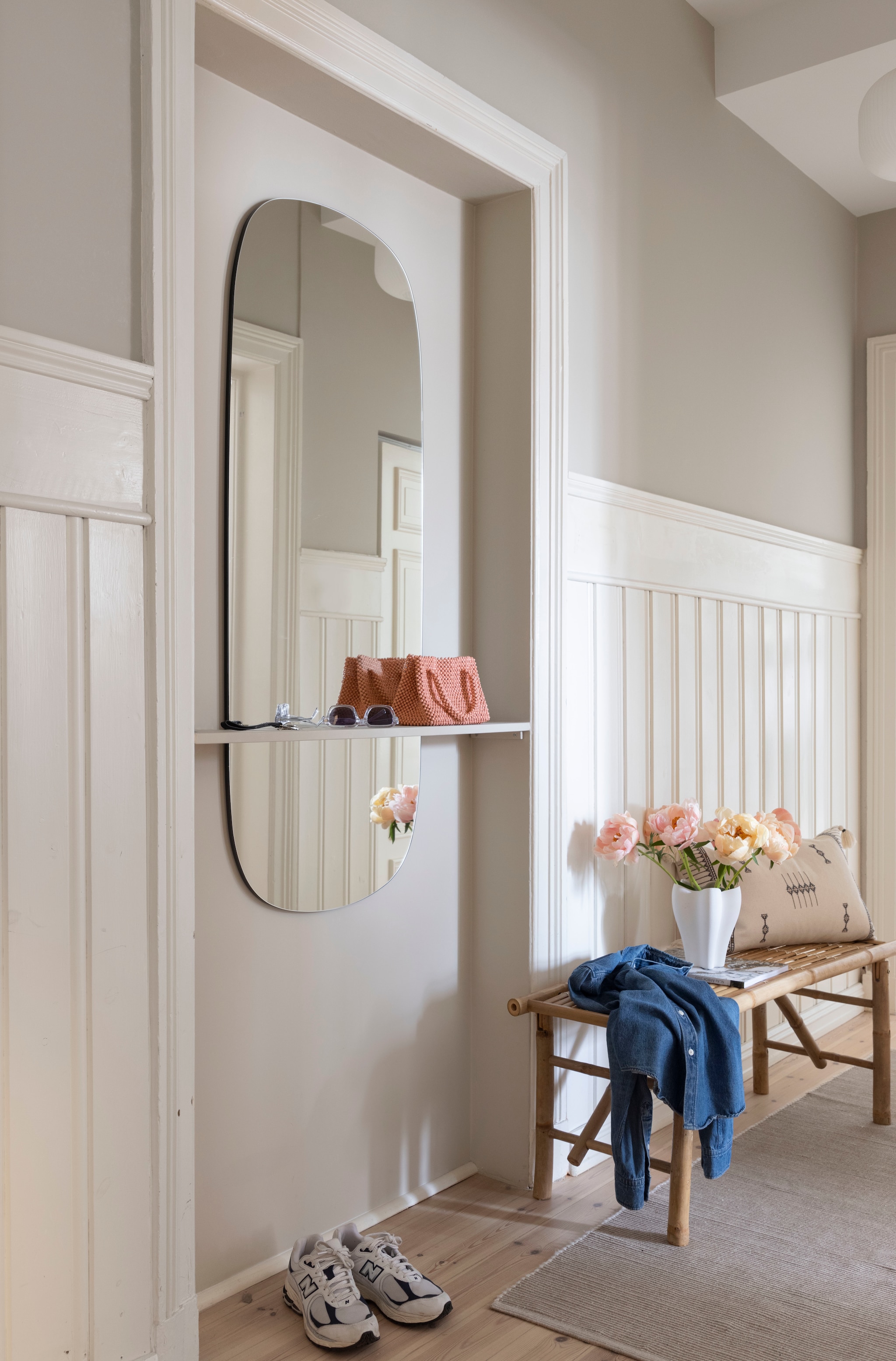 Rotan bank van Ib laursen, tweedehands gevonden. Spiegel van Incado met zelfgemaakte plank ervoor, geplaatst in dichtgemaakte deur. Wandkleur Sand van Jotun. vtwonen 01-2026 | styling Mari K. Olsen | fotografie Filippa Tredal | productie House of Pictures