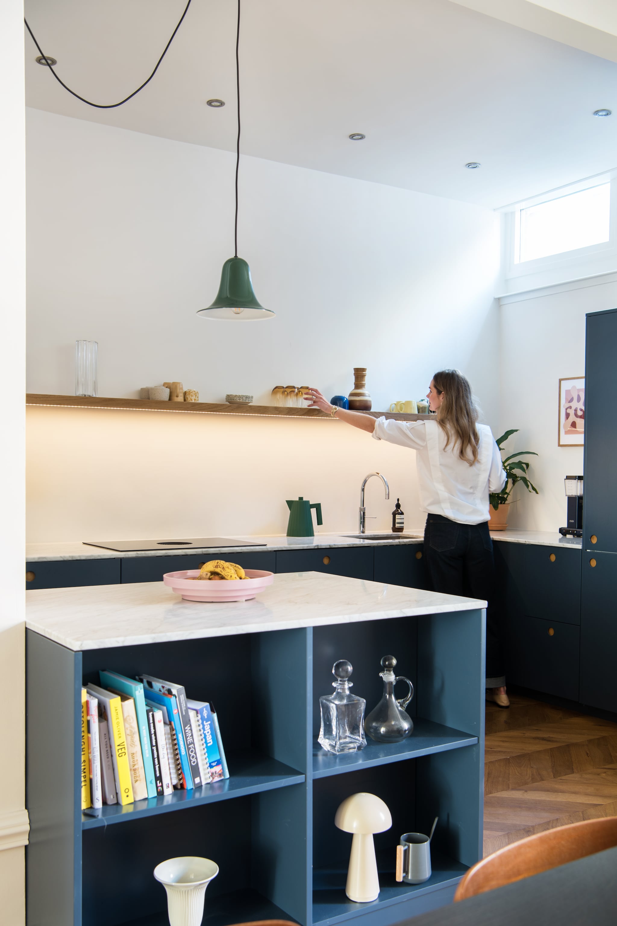 Keuken Reform. Hanglamp Verpan Pantop. Kopjes kringloop en Arket. Waterkoker Alessi. Fruitschaal HKliving. Karaffen van opa en oma. Paddenstoellamp Kwantum.  vtwonen 01-2026 | styling Jasmijn Stegeman | fotografie Anke Leunissen