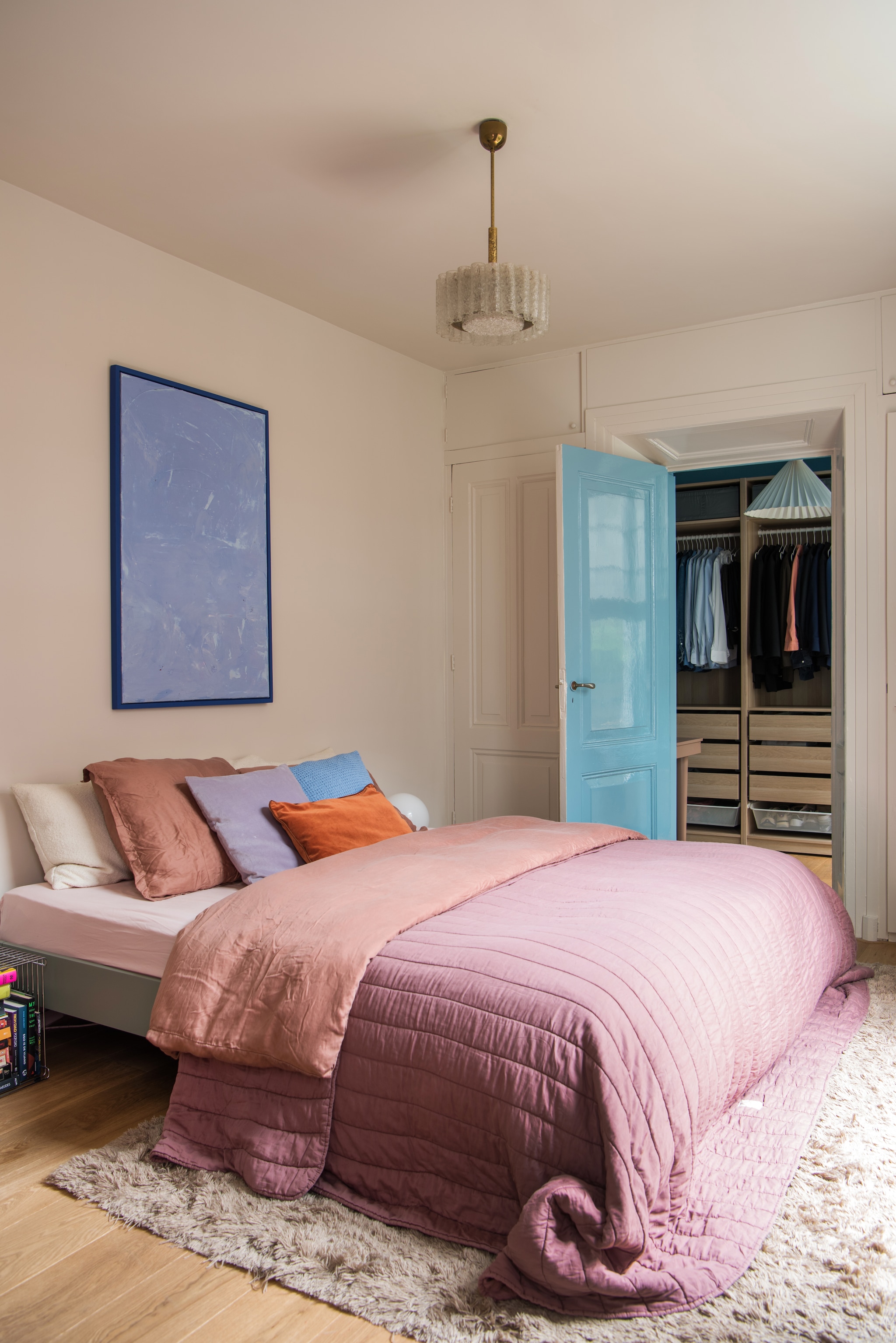 Muurverf Joanna van Little Greene. Verf deur Yonder van Farrow & Ball. Vloer naturel eiken. Vloerkleed Layered. Bed Auping. Kasten Ikea. Schilderij zelf gemaakt. Hanglamp boven bed Doria Leuchten. Hanglamp in kast Jotex. Dekbed Crisp Sheets. Kussens H&m Home en Zara Home.  vtwonen 01-2026 | styling Jasmijn Stegeman | fotografie Anke Leunissen