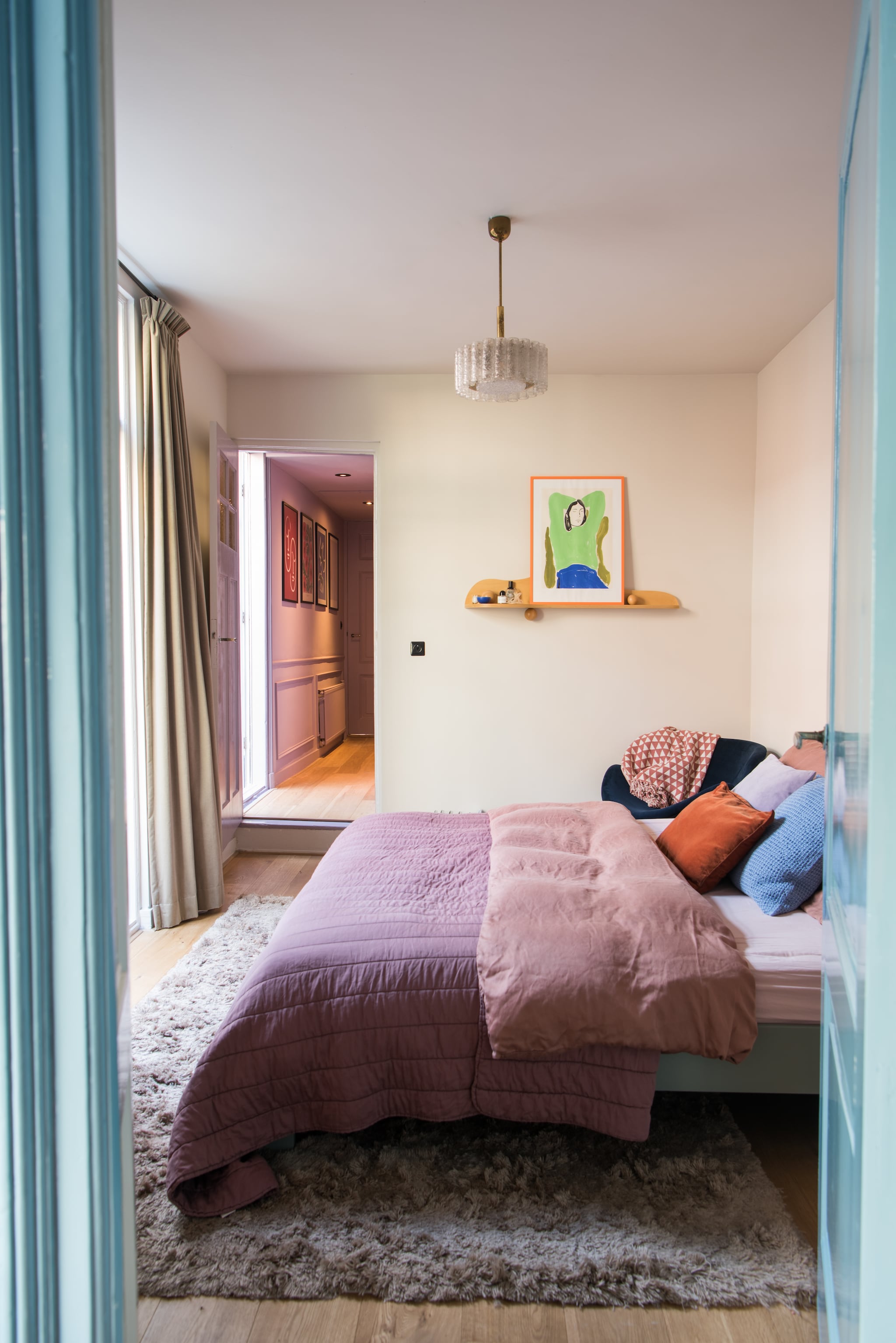 Muurverf Joanna van Little Greene. Gordijnen Hema. Vloerkleed Layered. Wandplank Studio Jes Iken. Poster The Poster Club. Bed Auping. Dekbed Crisp Sheets. Kussens H&m Home en Zara Home.  vtwonen 01-2026 | styling Jasmijn Stegeman | fotografie Anke Leunissen