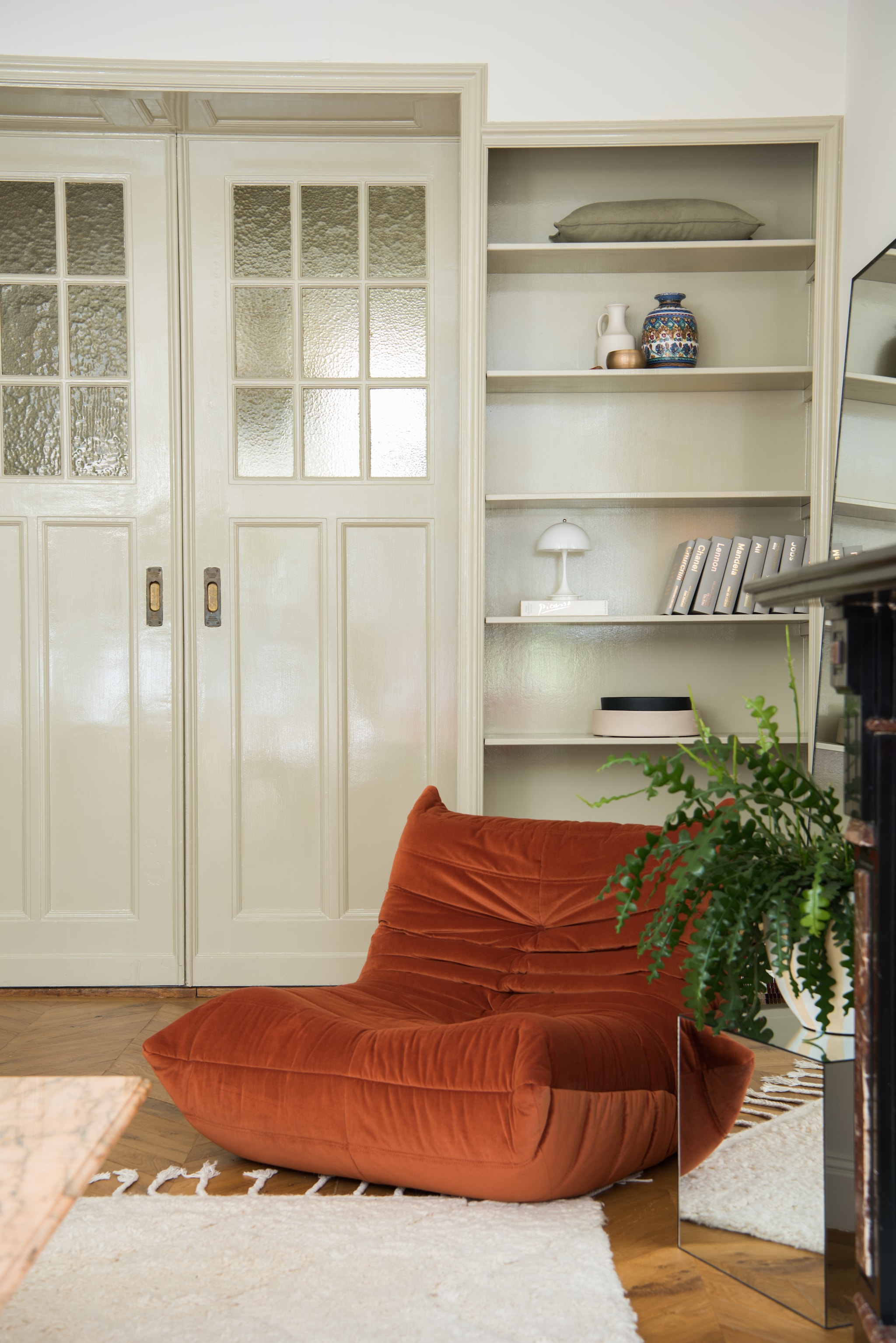 Houtverf Old White van Farrow & Ball. Vloer Hongaarse punt in naturel eiken. Fauteuil Togo van Ligne Roset. Vloerkleed Marokkaans berberkleed. Bijzettafel Karwei. Vazen kringloop. Lamp Panthella van Louis Poulsen.  vtwonen 01-2026 | styling Jasmijn Stegeman | fotografie Anke Leunissen