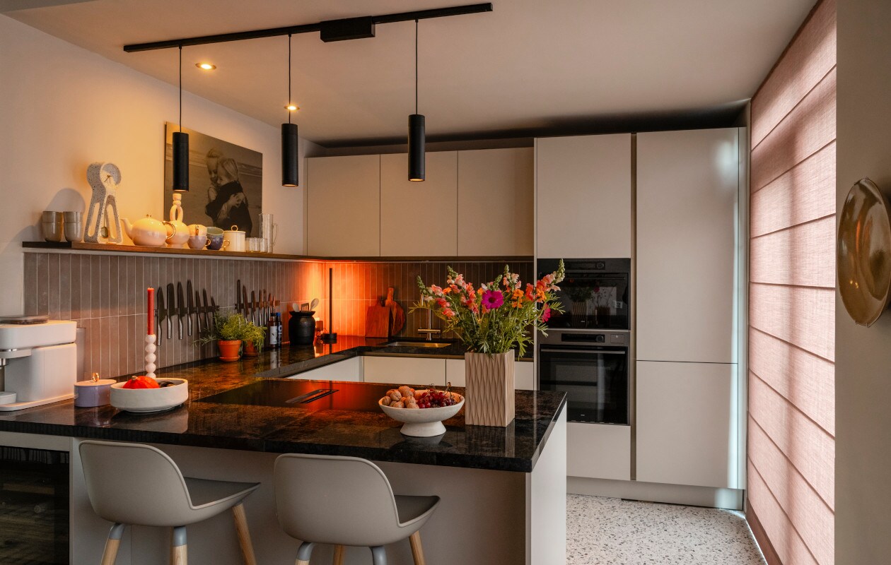 Spots, hanglampen en een tafellamp: samen zorgen ze in de keuken voor precies de juiste sfeer, op elk moment.