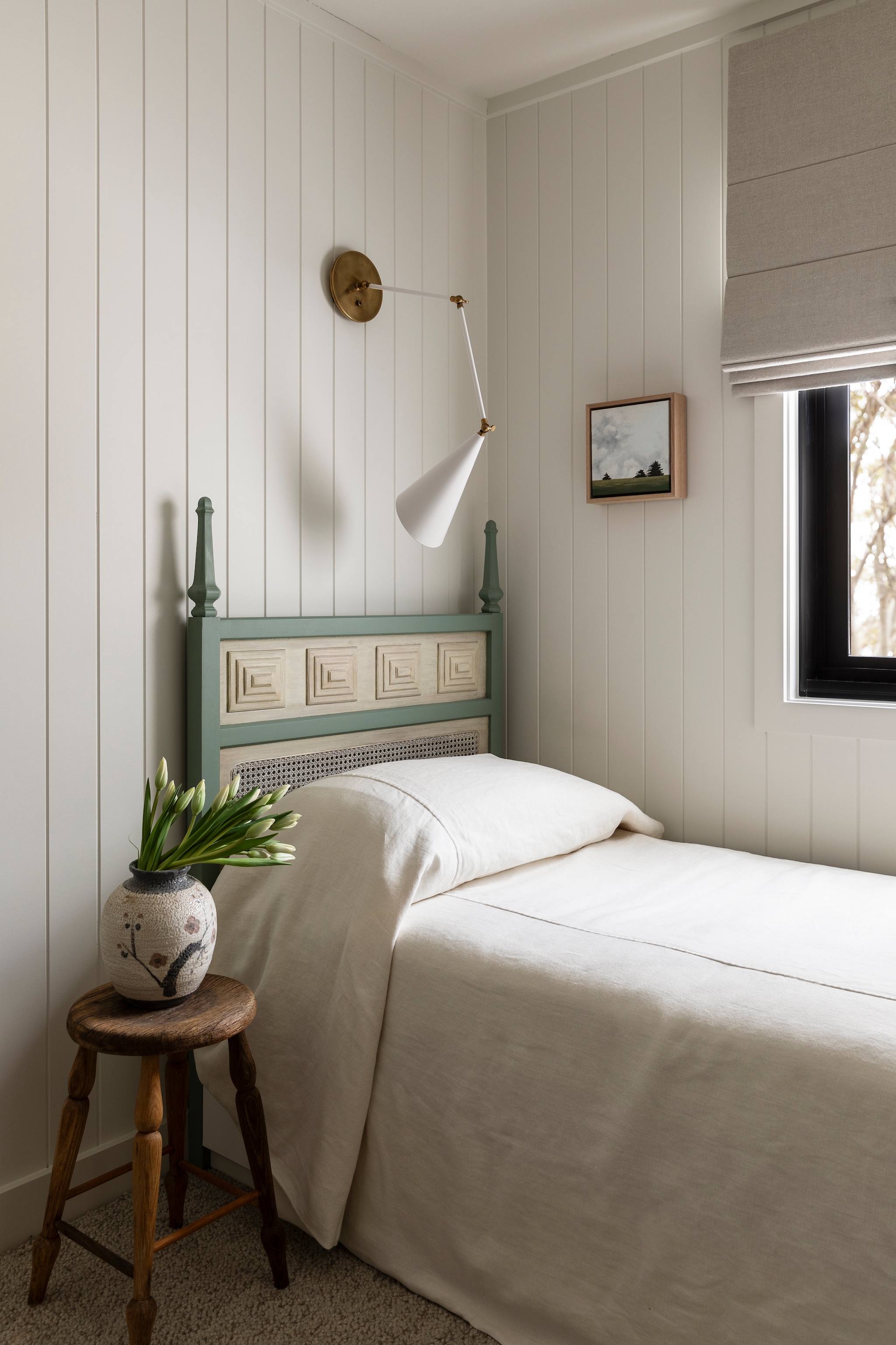 Lamp The Montauk Lighting Company. Beddengoed Cultiver. Bed gemaakt van twee vintage hoofdeinden die opnieuw geverfd zijn. Het bedframe is erbij gemaakt en kan uitgeschoven worden tot een tweepersoonsbed. vtwonen Landelijk 01-2026 | fotografie Martina Gemmola | productie Living Inside