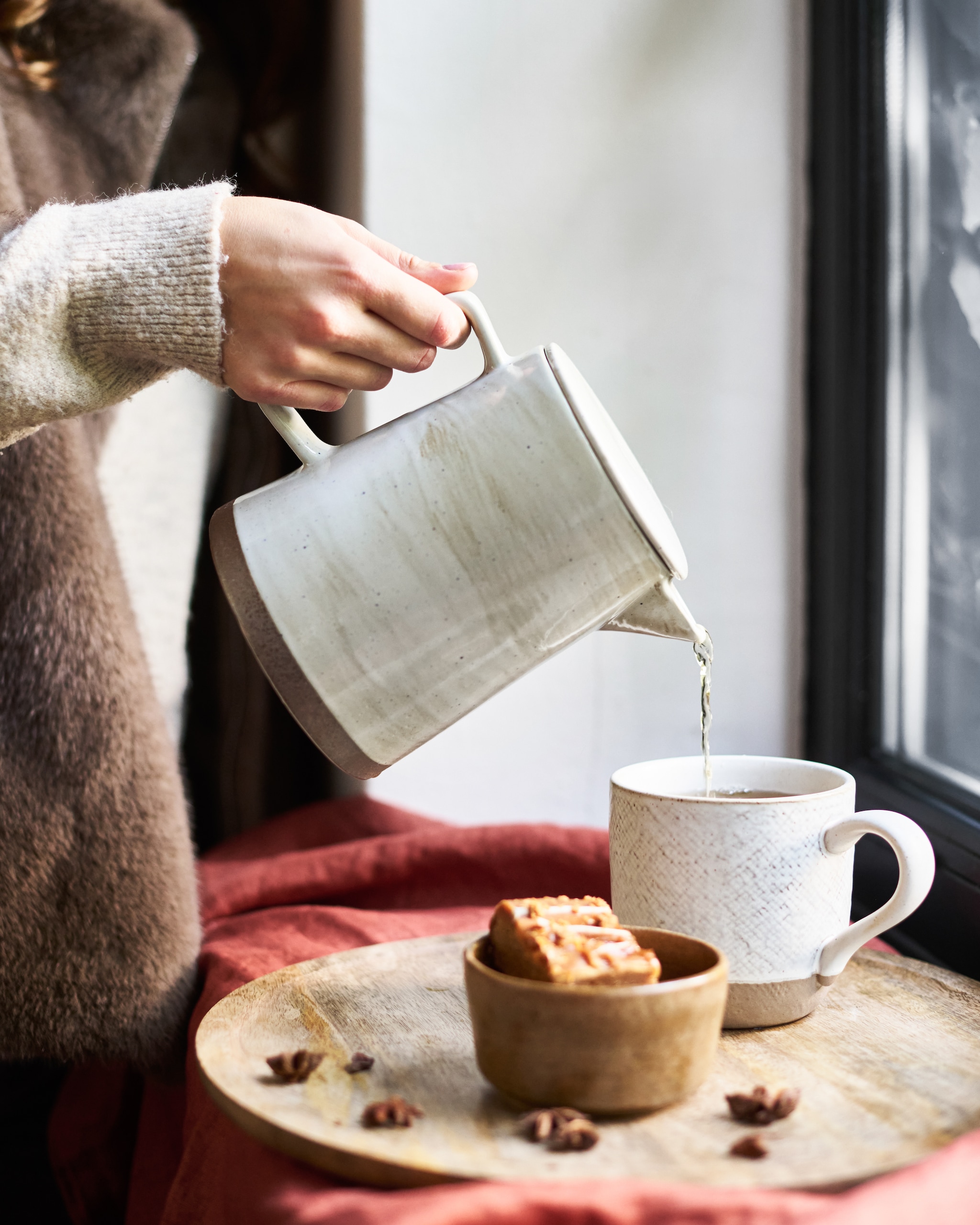 Mica Decorations bord Duko, mangohout, bruin € 23,95, Raw Materials bijzettafel Nero Ray, teak, 45x45x50 cm (bxdxh) € 229,- (shop.vtwonen.nl).  Zara Home mok, met reliëfpatroon, oyster white € 9,99, kom, steengoed, pumpkin € 6,99 (zarahome.com). Broste Copenhagen theepot Grød, keramiek, grijs, 1,3 liter€ 85,50 (brostecopenhagen.com).Overig privébezit. vtwonen Landelijk 12-2025 | styling Sanne Keetelaar | fotografie Sjoerd Eickmans
